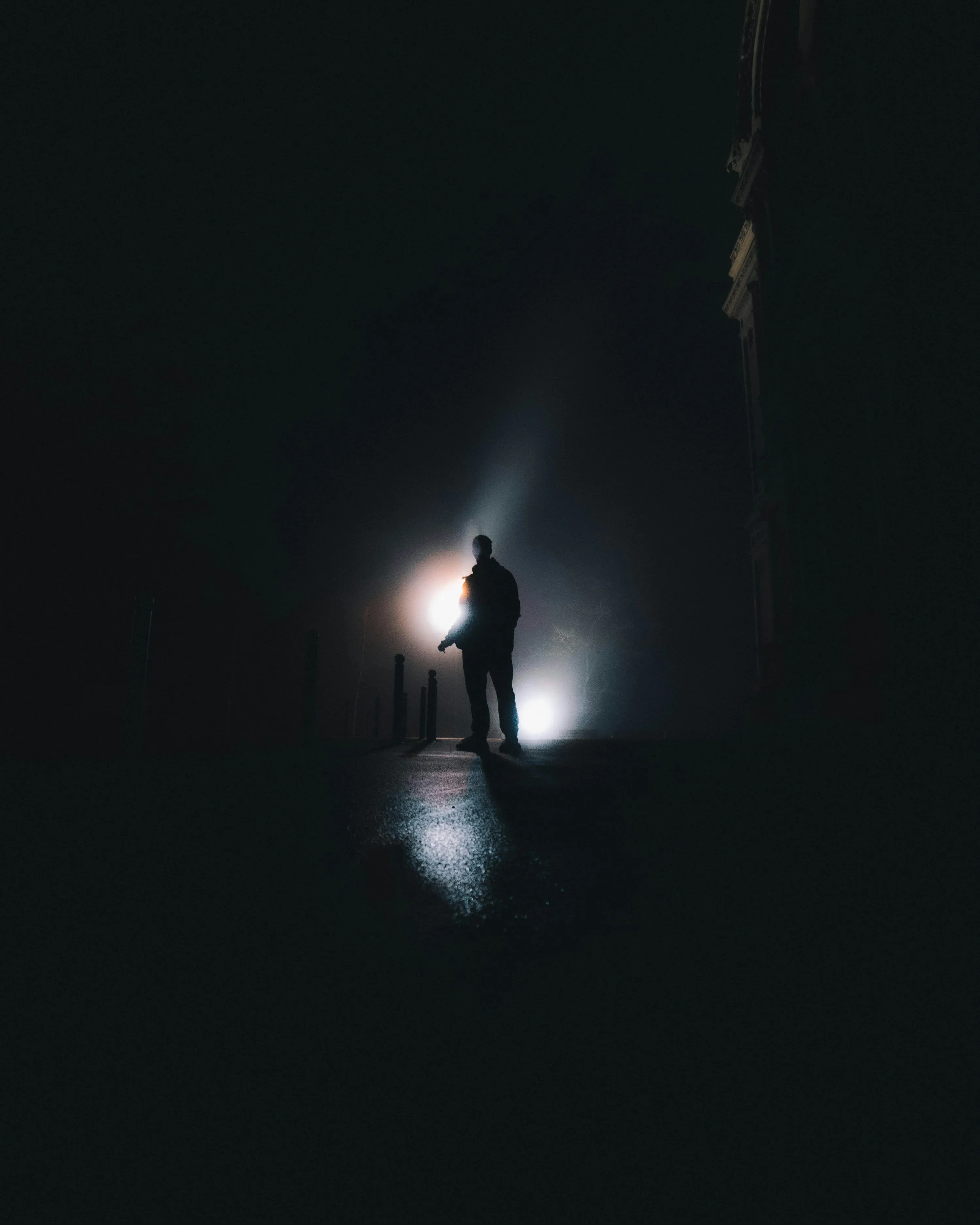 Silhouette of person standing in the middle of the dark photo