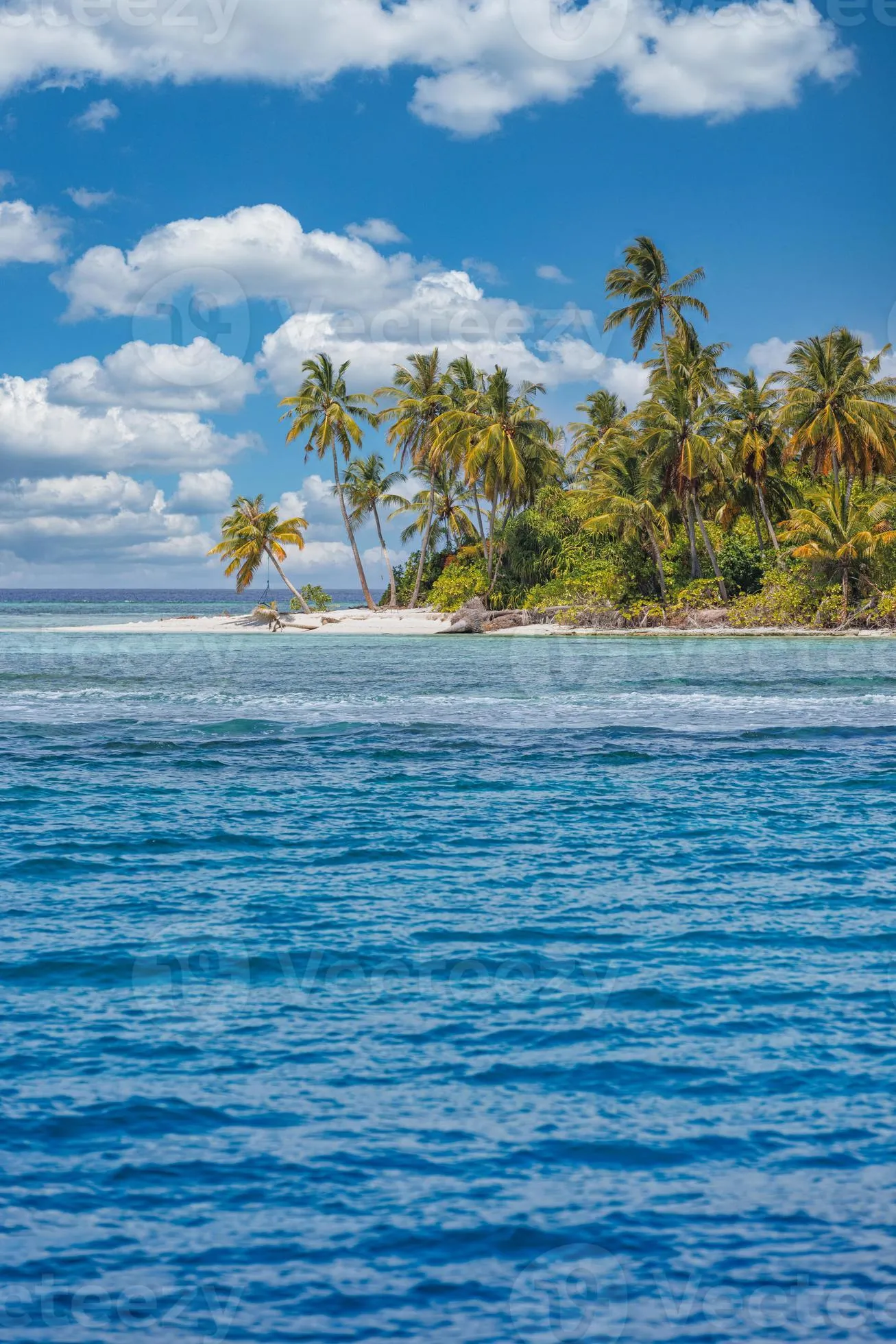 Beautiful tropical beach with white sand, palm trees, turquoise ocean against blue sky with clouds on sunny summer day. Perfect island landscape background for relaxing vacation. Exotic paradise coast 13082343