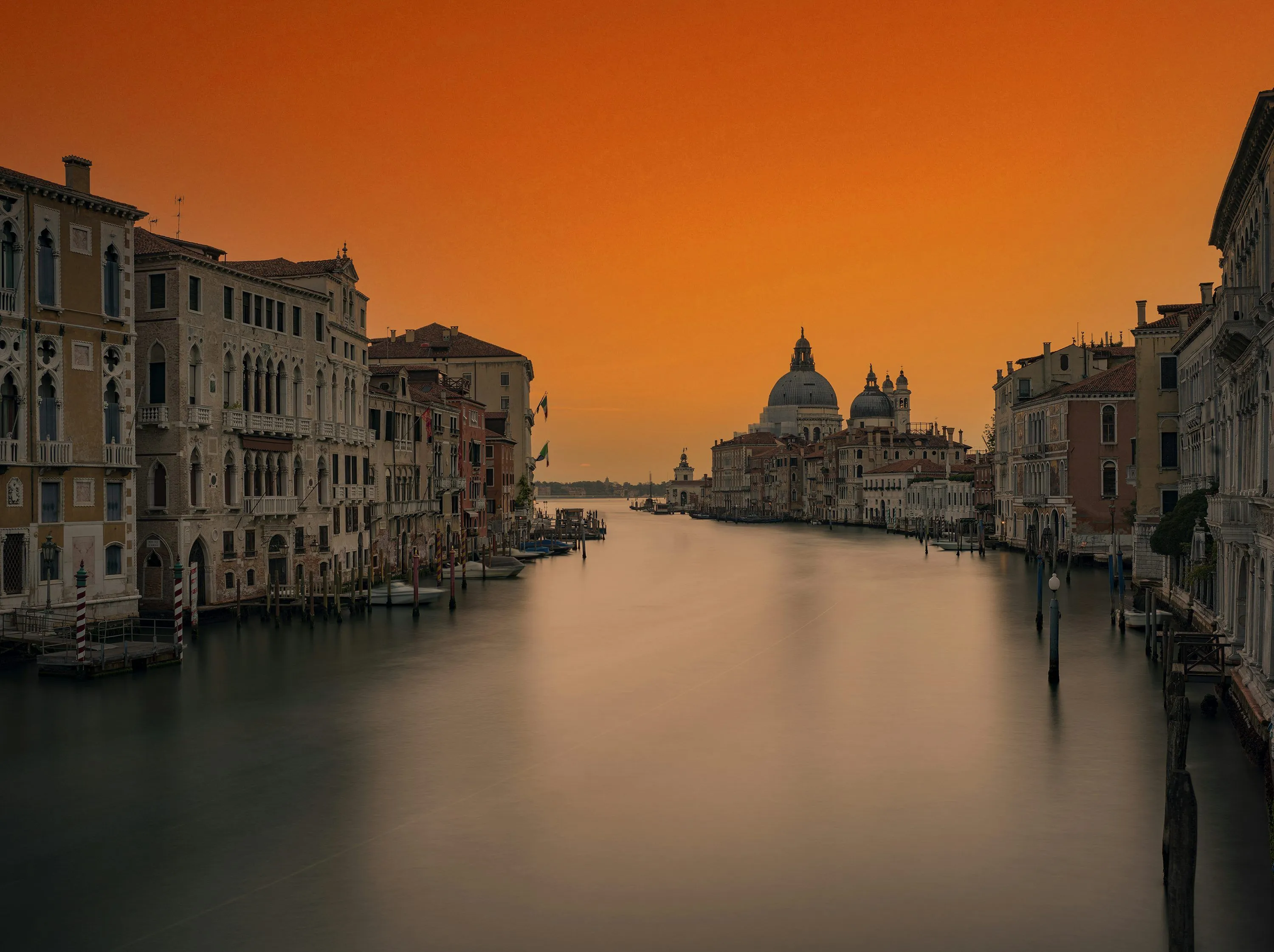 A view of a canal with buildings and a dome in the distance photo