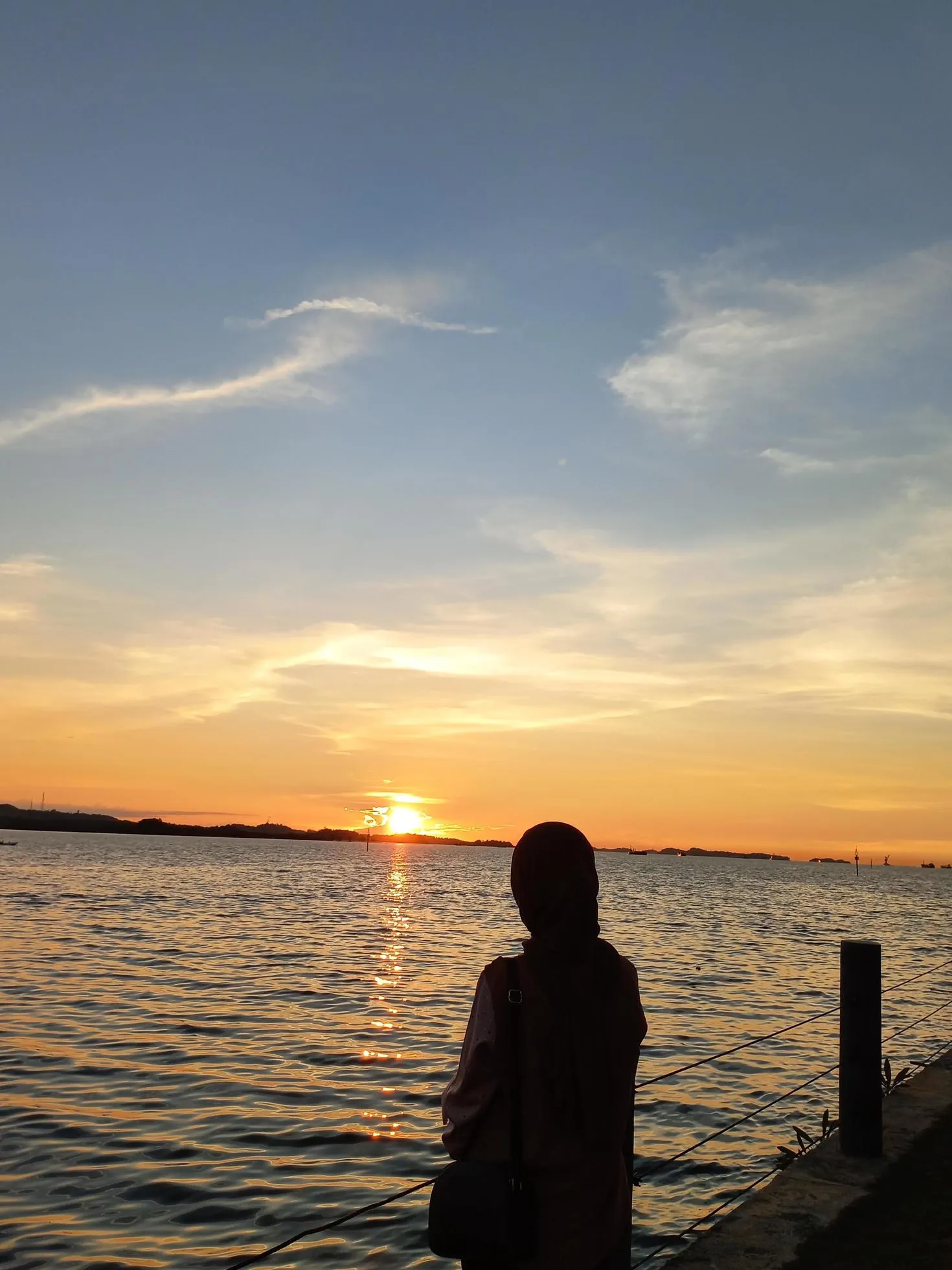 Muslim hijab enjoying the sunset on the beach