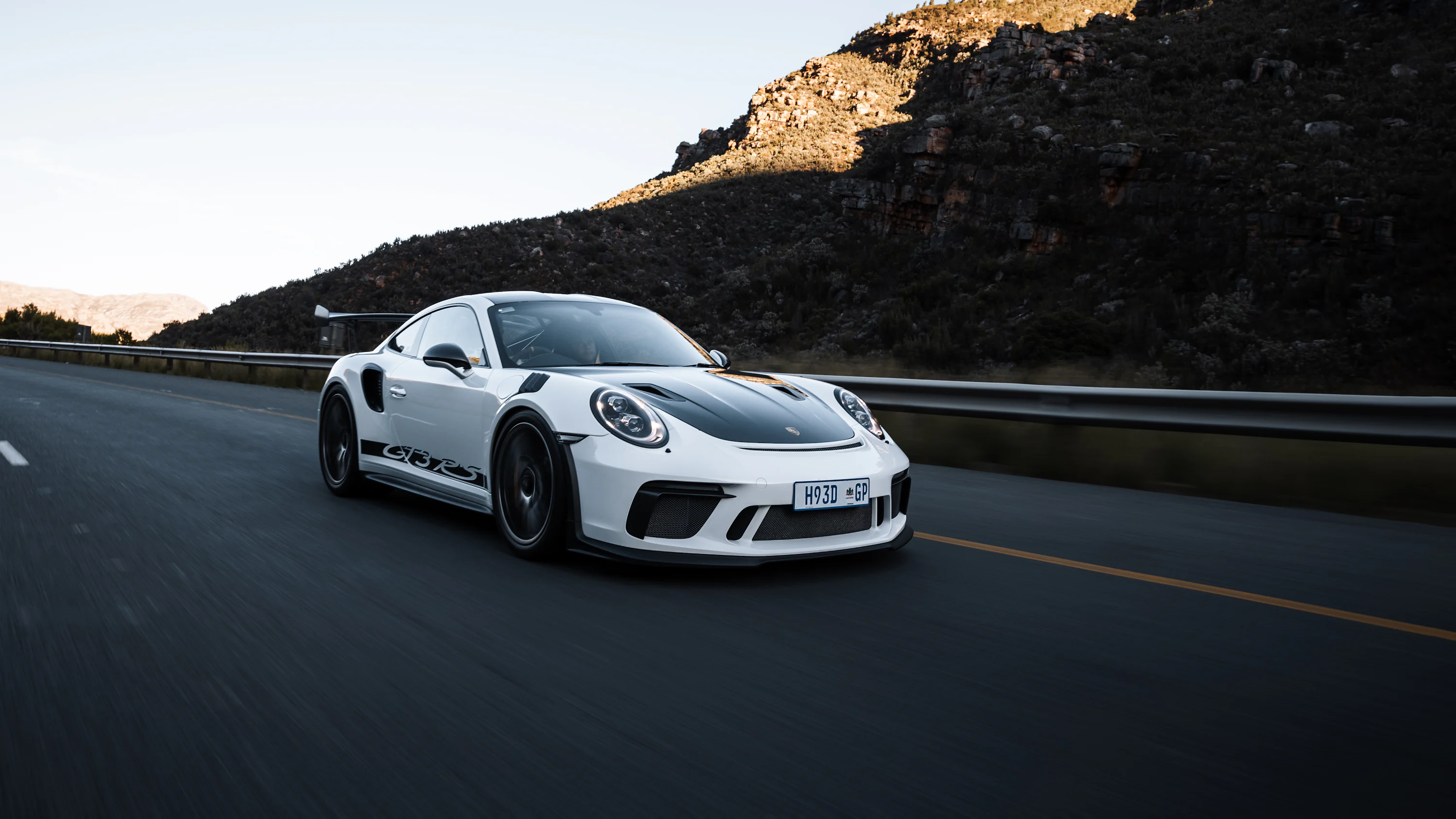A white sports car driving down the road photo
