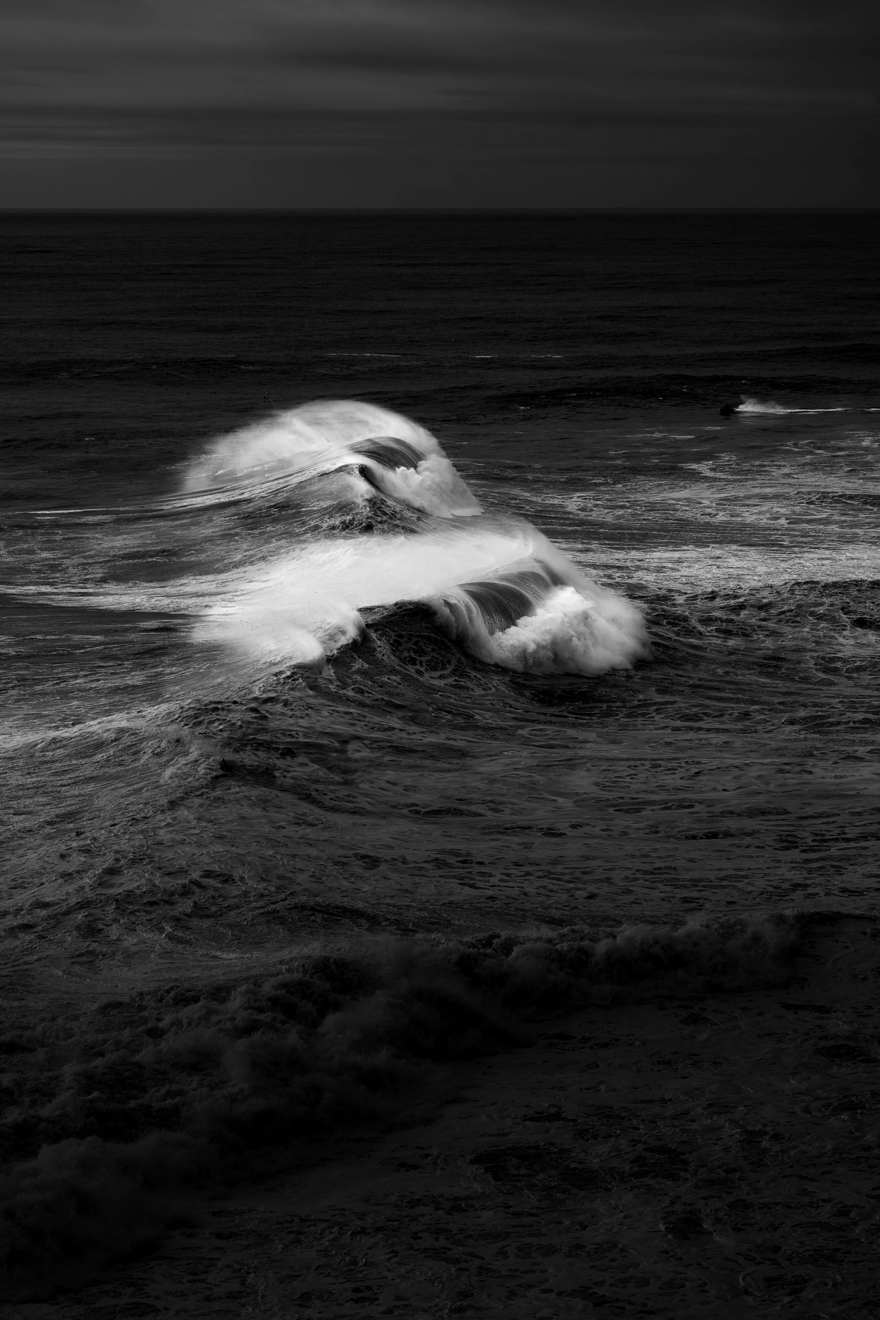 A black and white photo of waves in the ocean photo