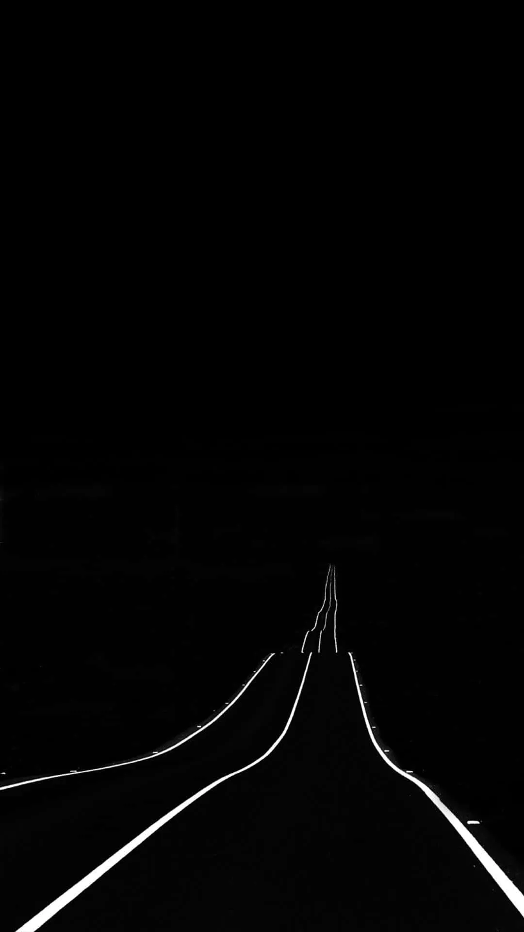 Download A Black And White Photo Of A Road With Lights Wallpaper