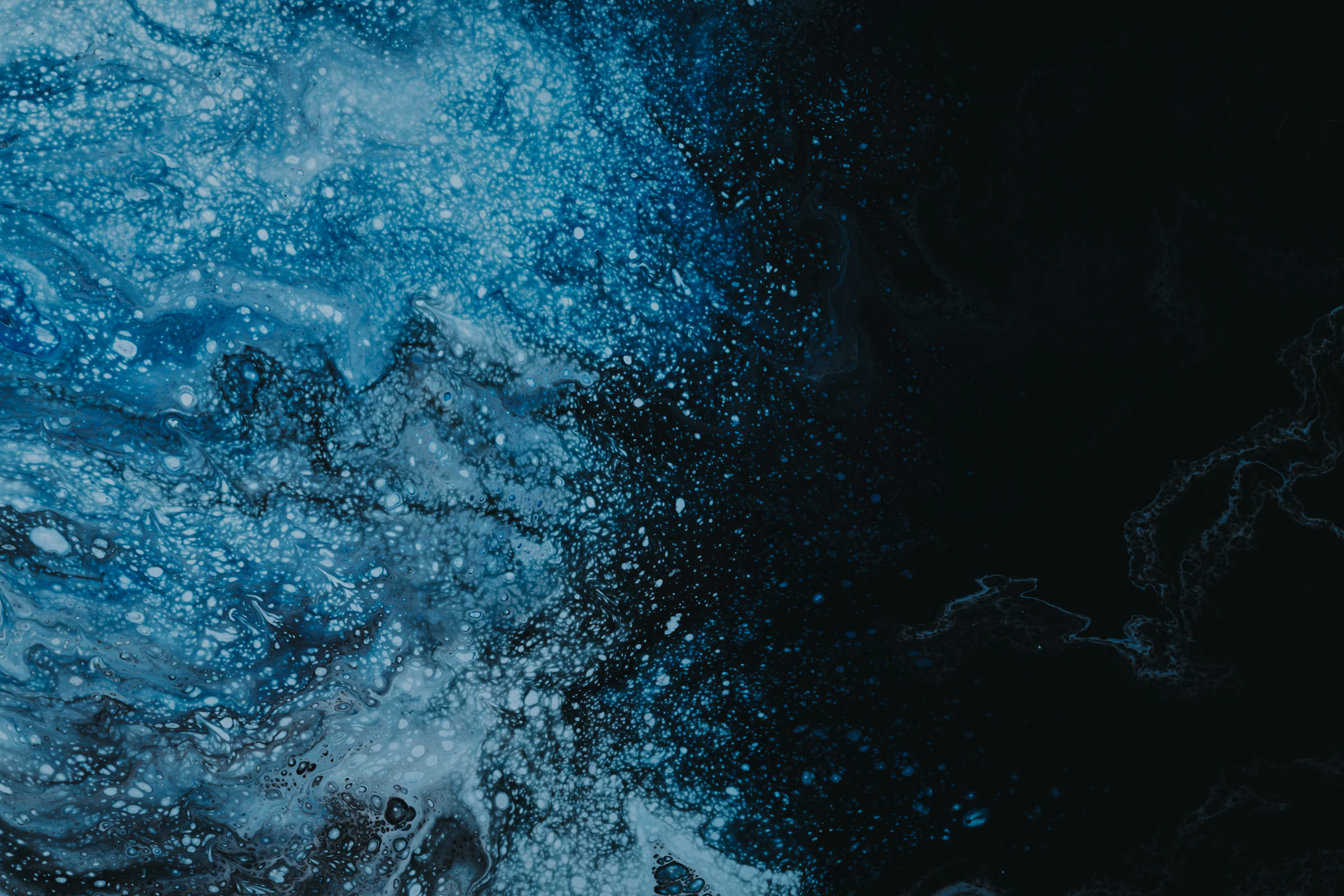 A black and blue background with water splashing on it photo