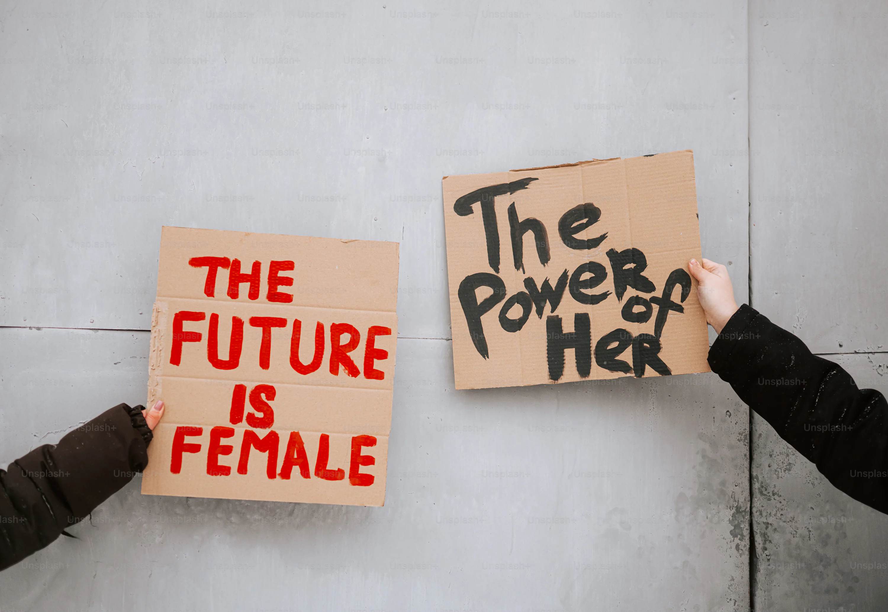 Two signs held up with feminist messages photo