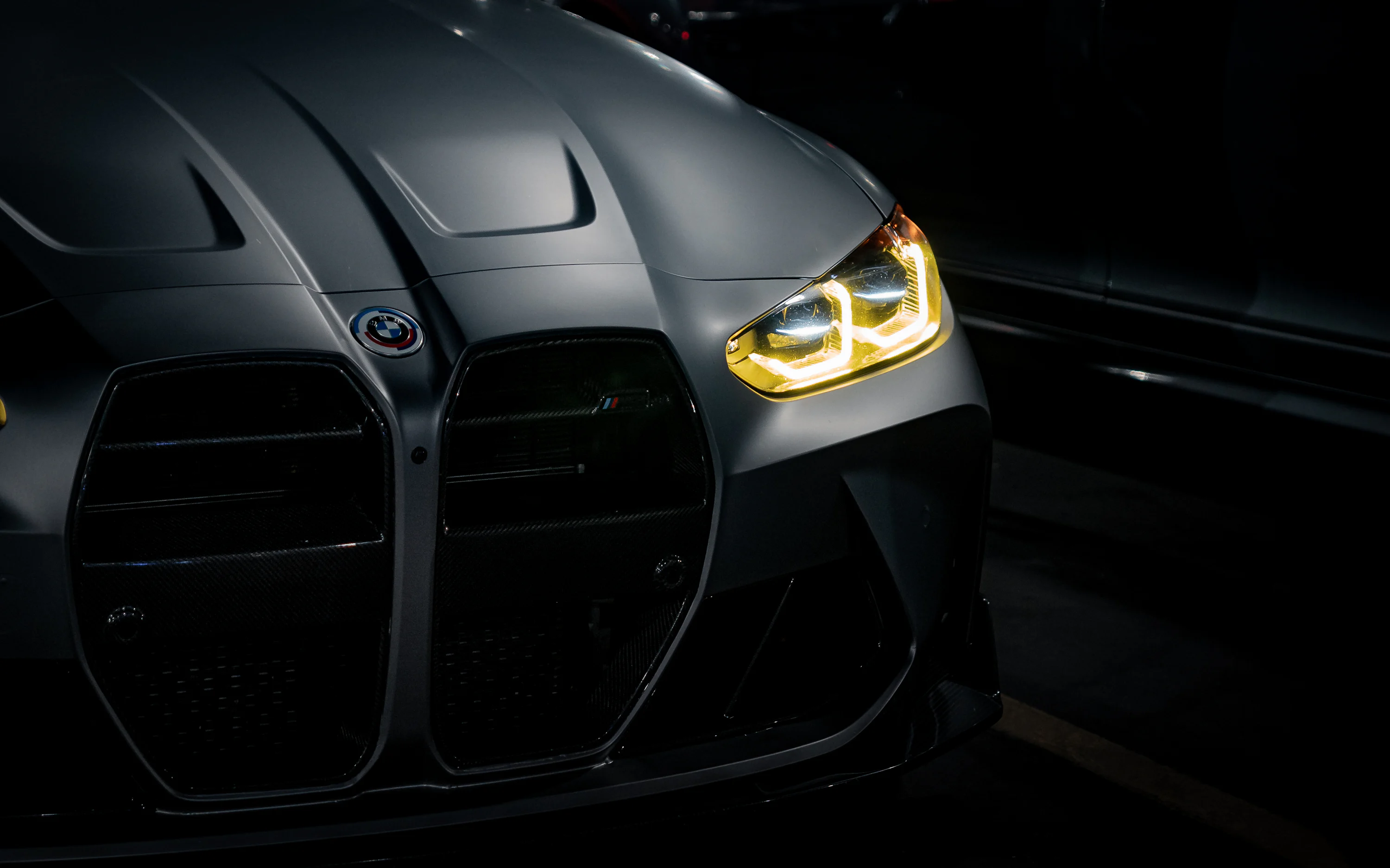 The front of a black sports car in the dark photo
