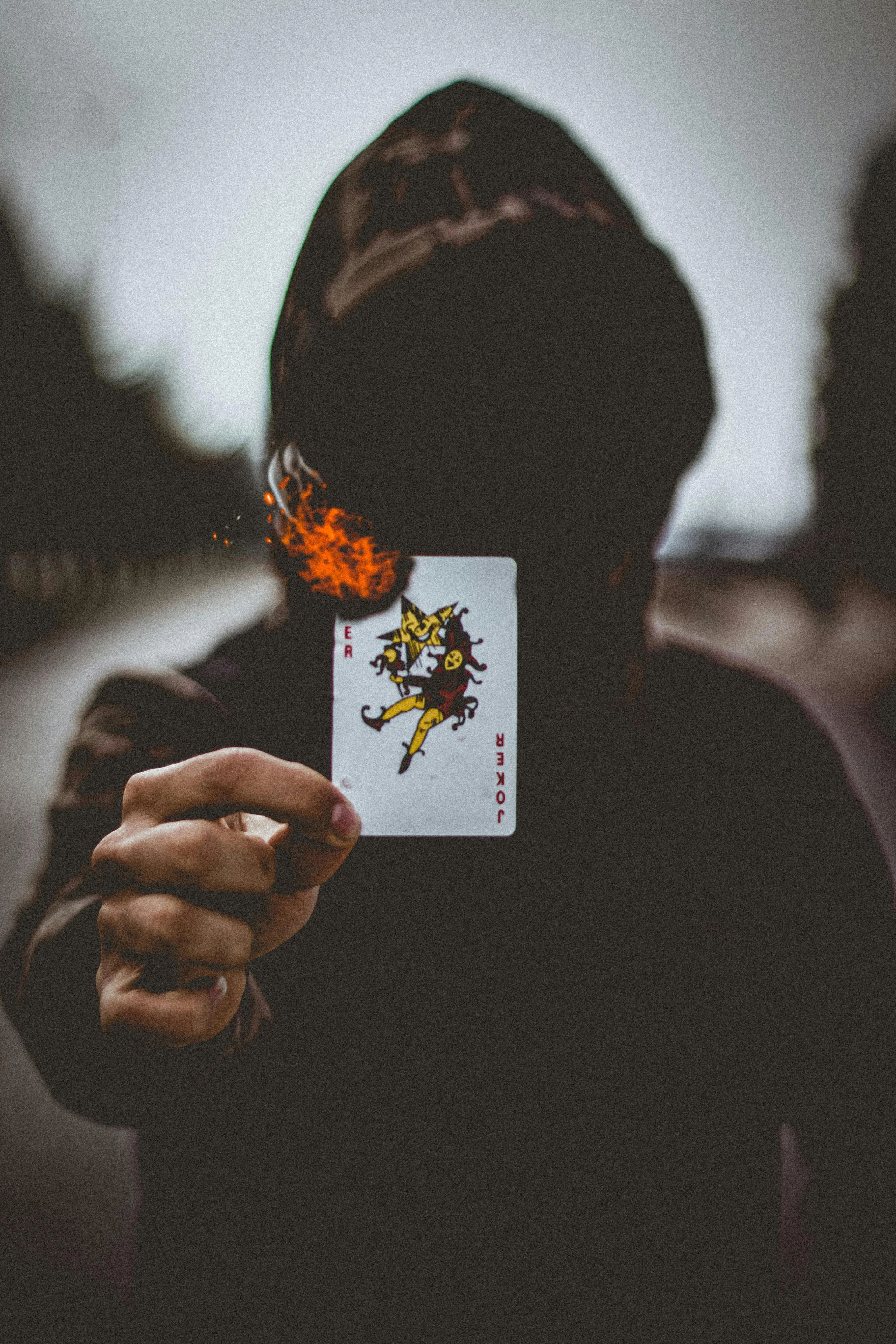 A Person Wearing Hoodie Holding a Burning Card · Free