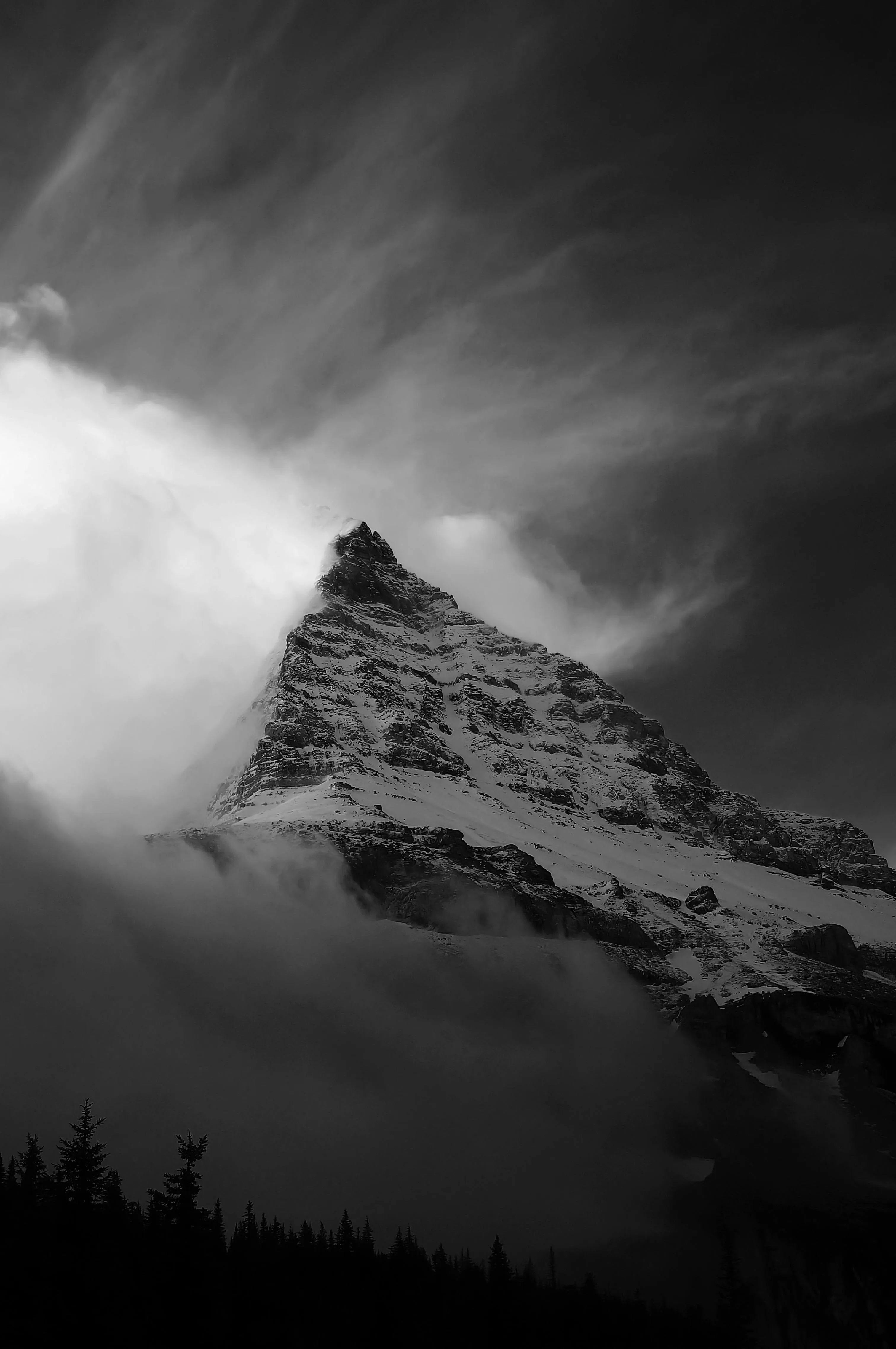 Grayscale Photo of Snow Covered Mountain under a Cloudy Sky · Free