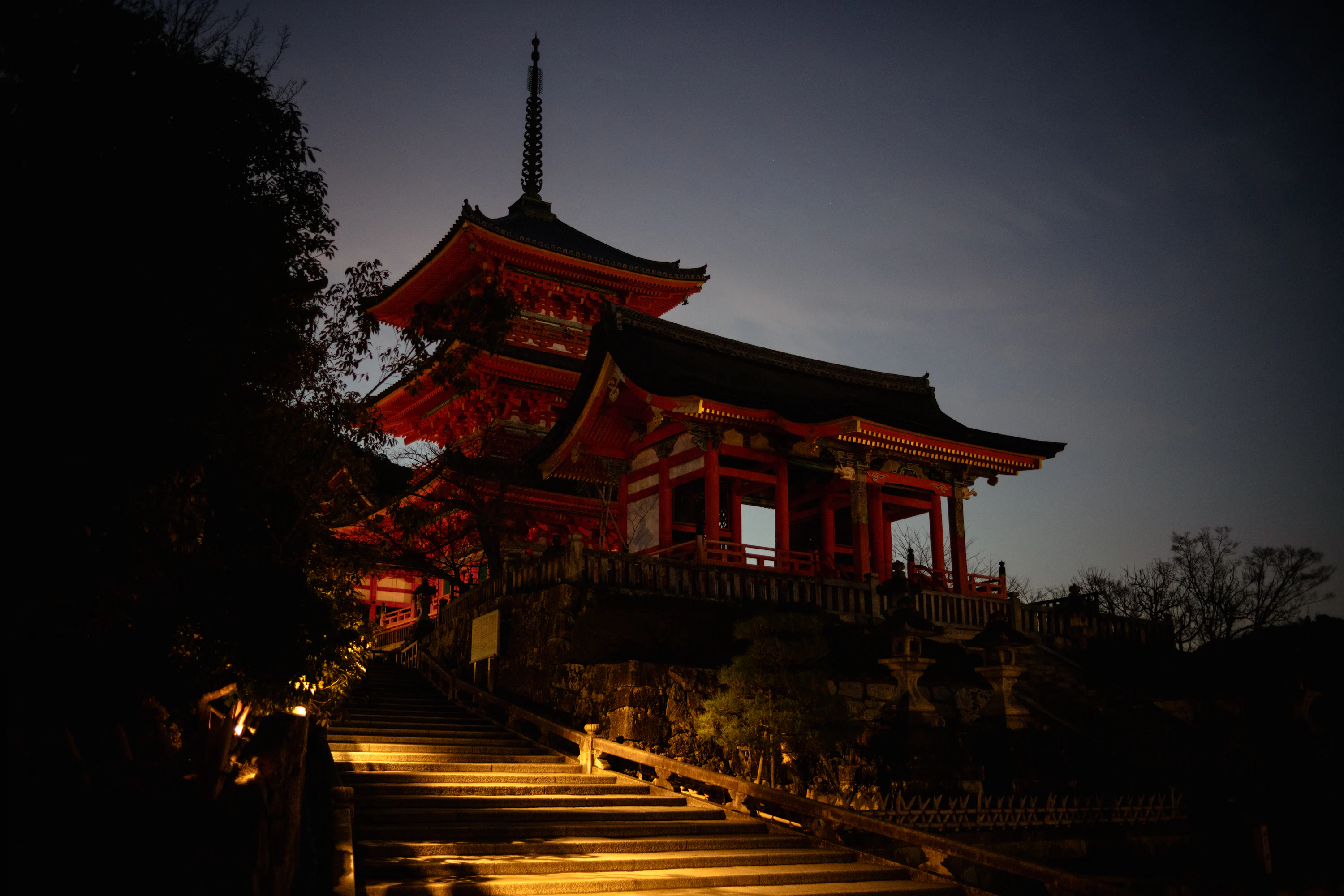 A japanese temple illuminated at dusk with a dark sky photo