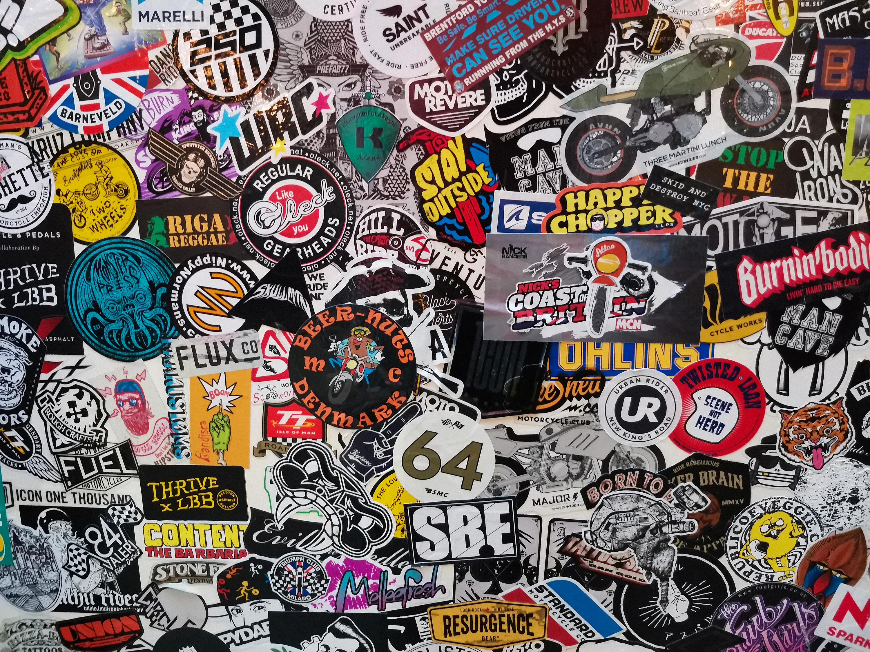 A wall is covered with many different stickers. photo