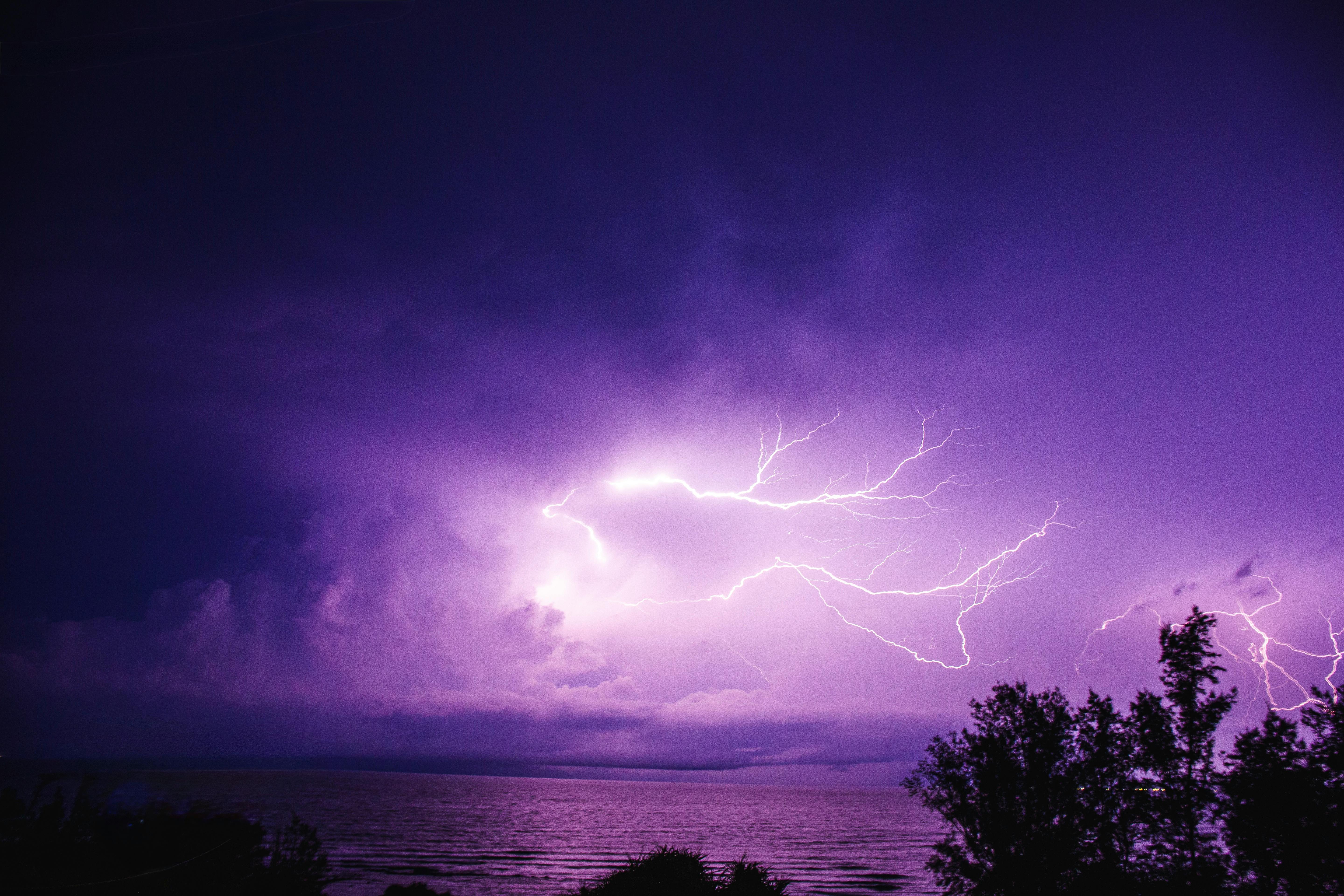 Purple Lightning Strikes Over Ocean at Night · Free
