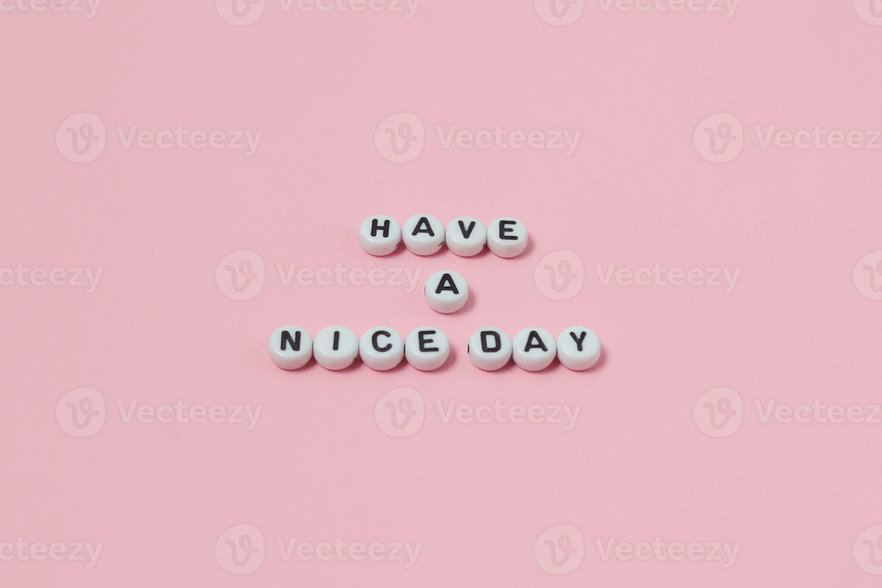 Top view of Have a nice day quotes made out of beads on pink background. motivation and success concept
