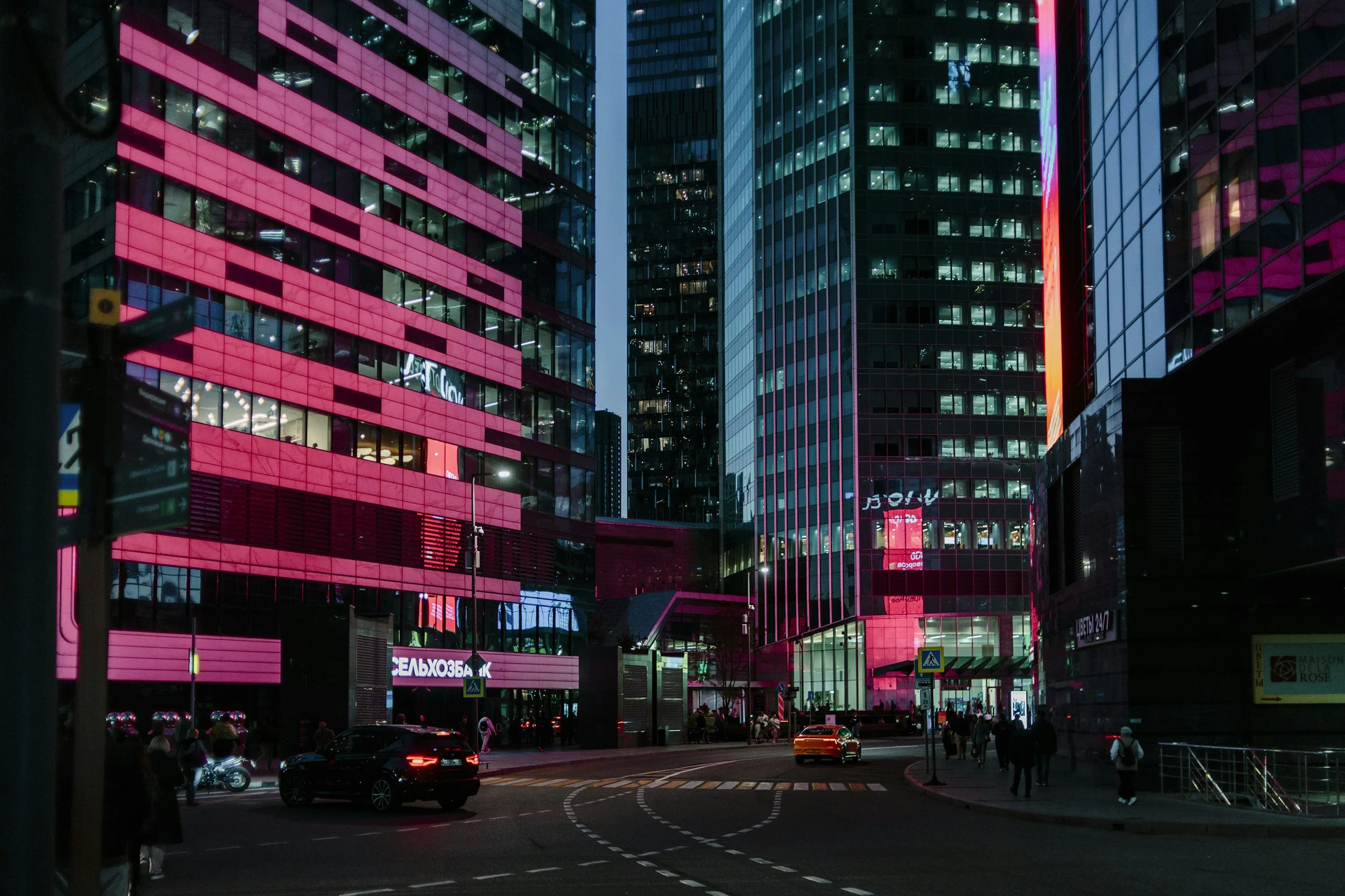 Vibrant city street at night with pink lights. photo