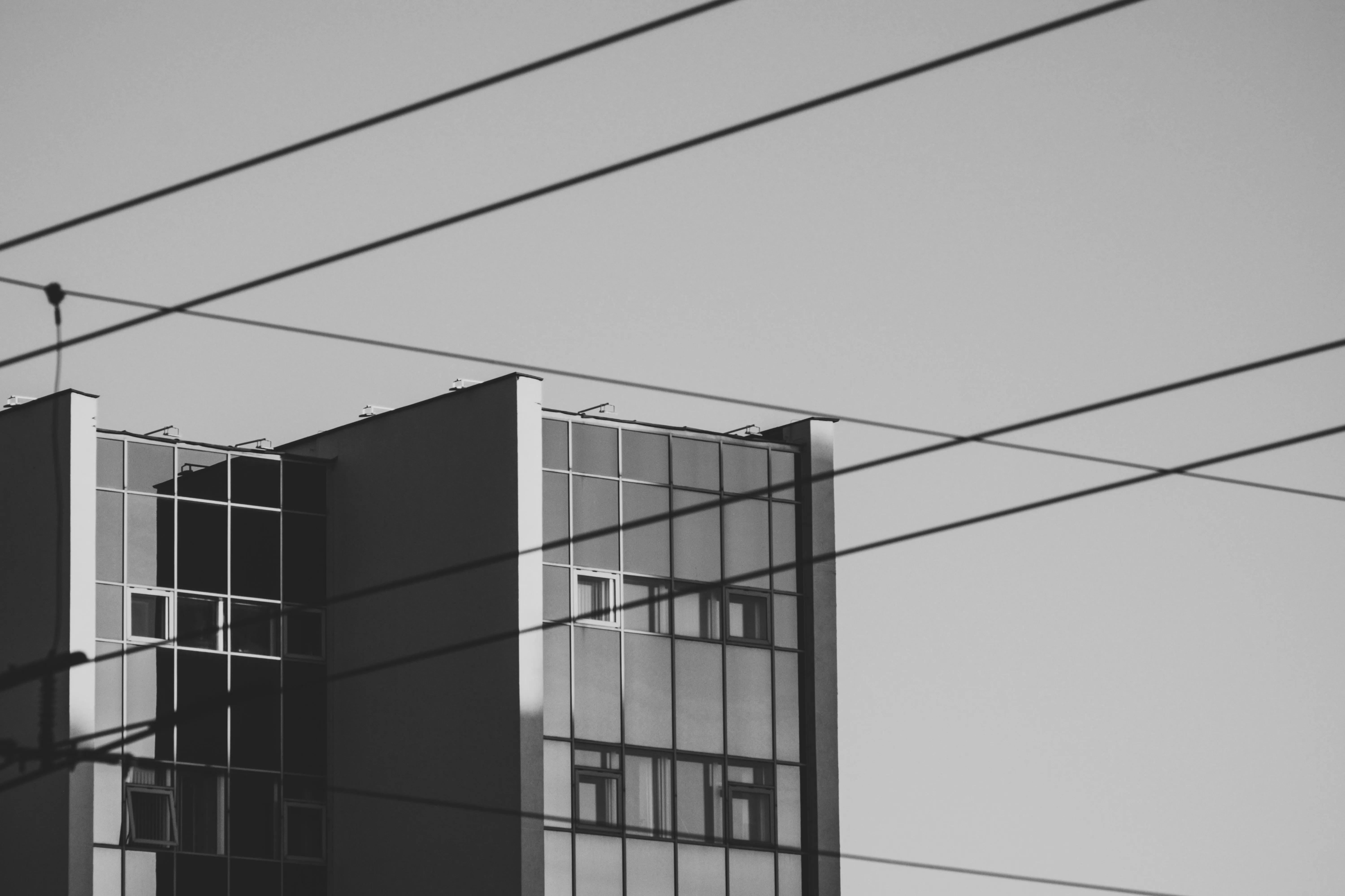 Monochrome Photography Of A Brutalist Building With Power Lines HD Wallpaper