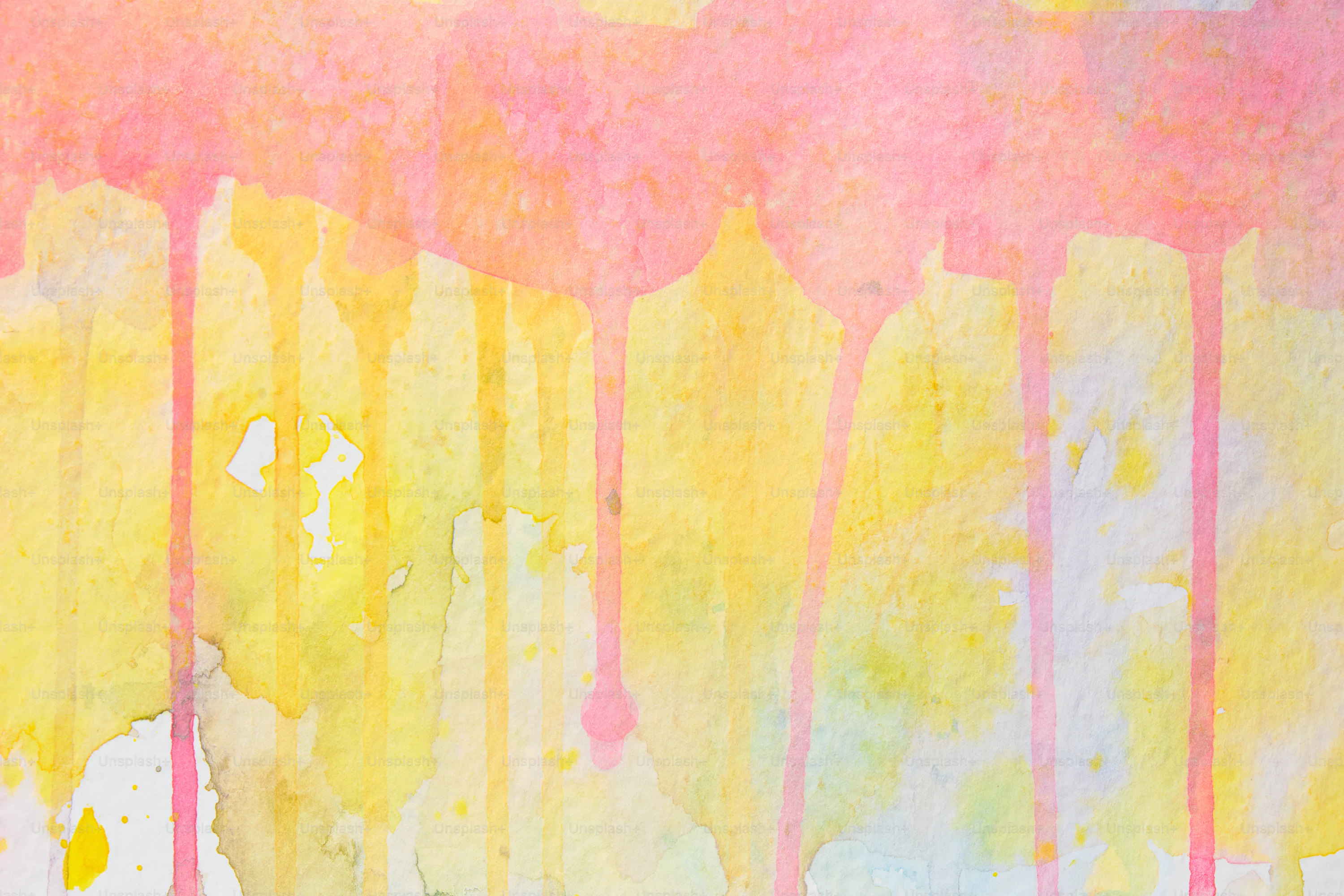 Pink and yellow paint drips down the paper. photo