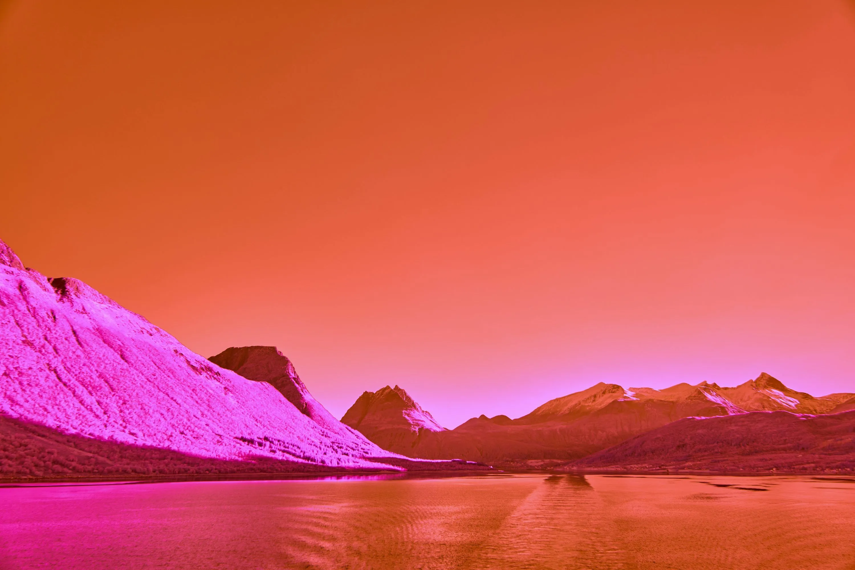 A red and pink photo of a mountain range photo