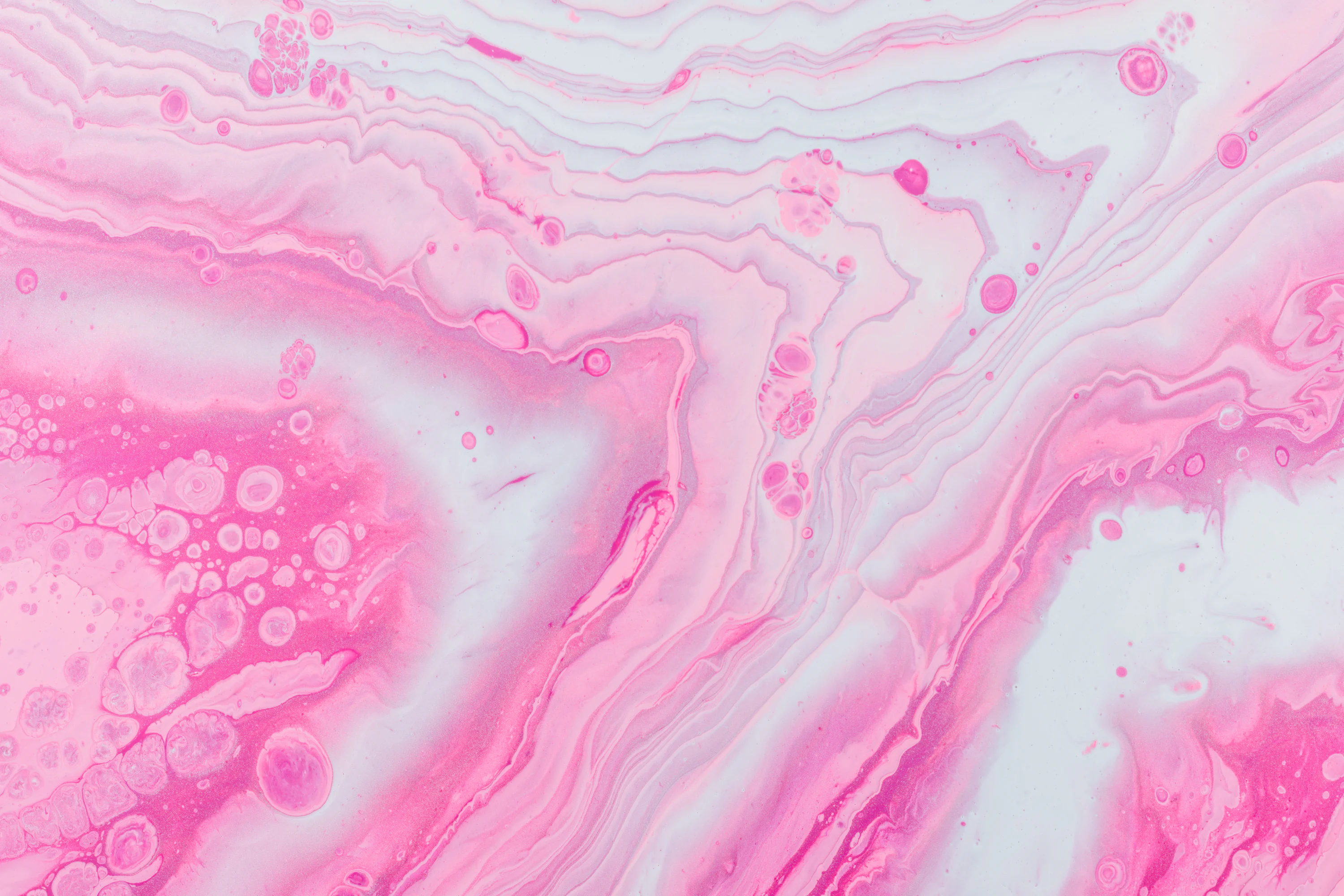 A close up of a pink and white marble surface photo