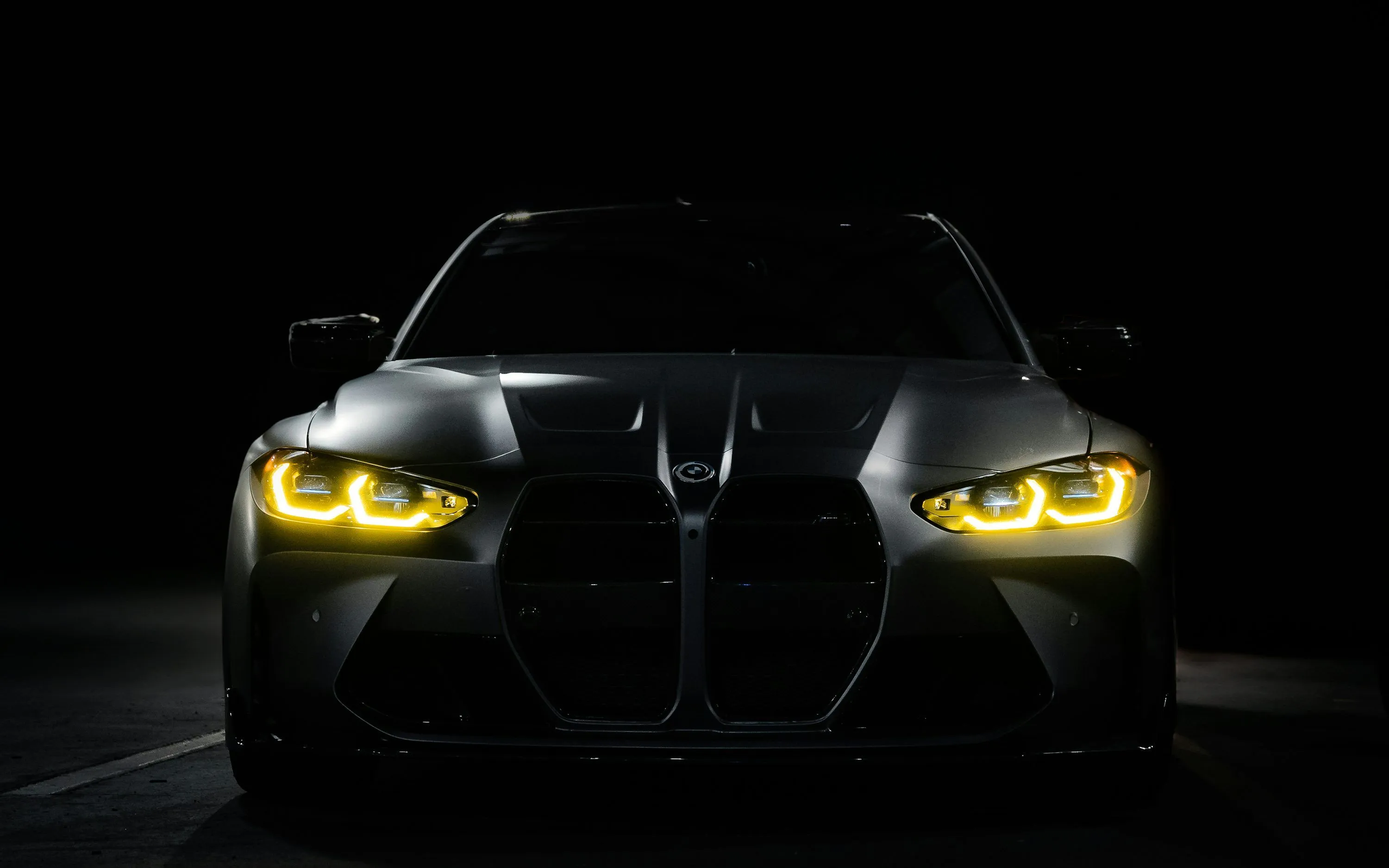 The front of a black sports car in the dark photo