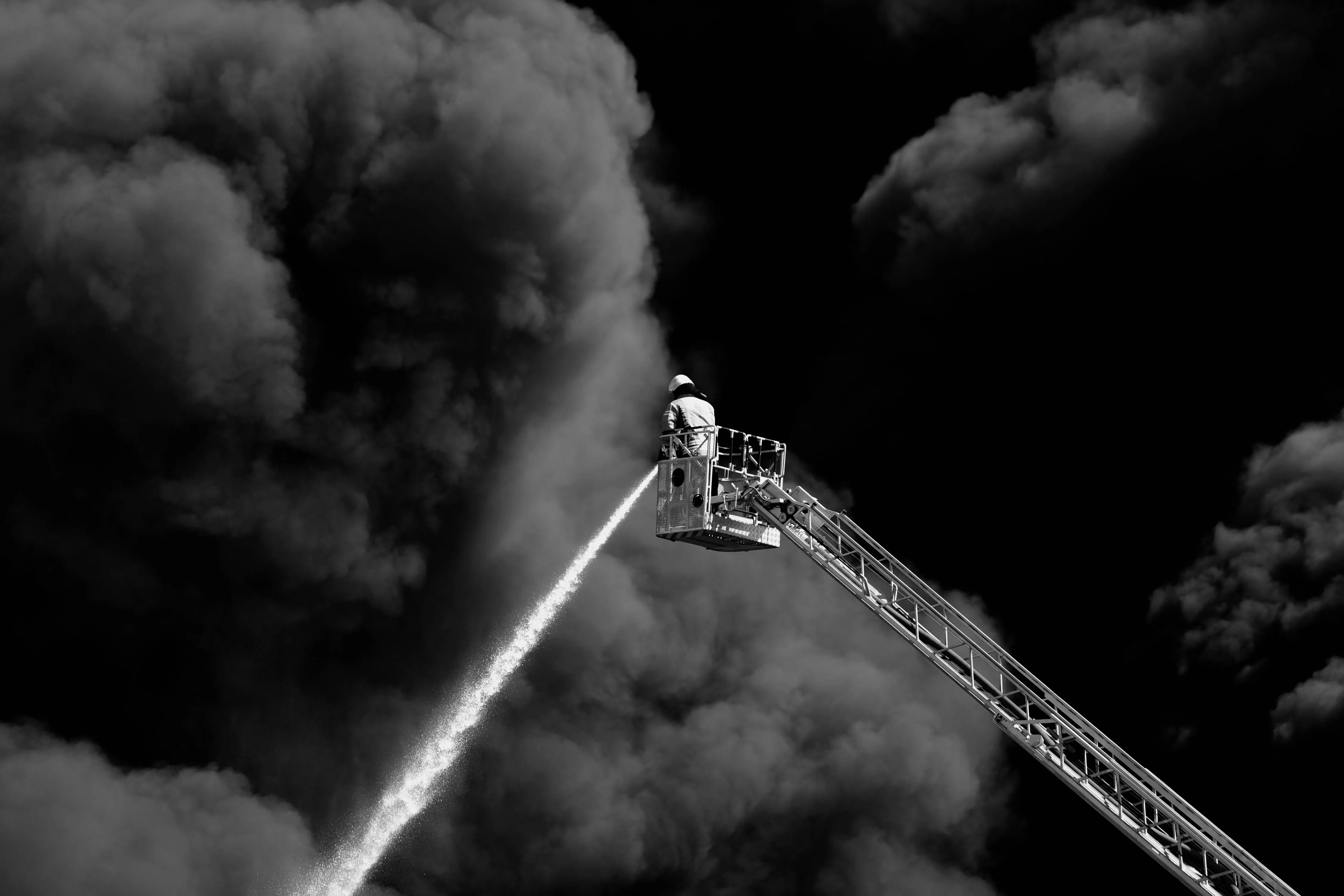 Firefighter on a Crane Extinguishing a Large Fire · Free