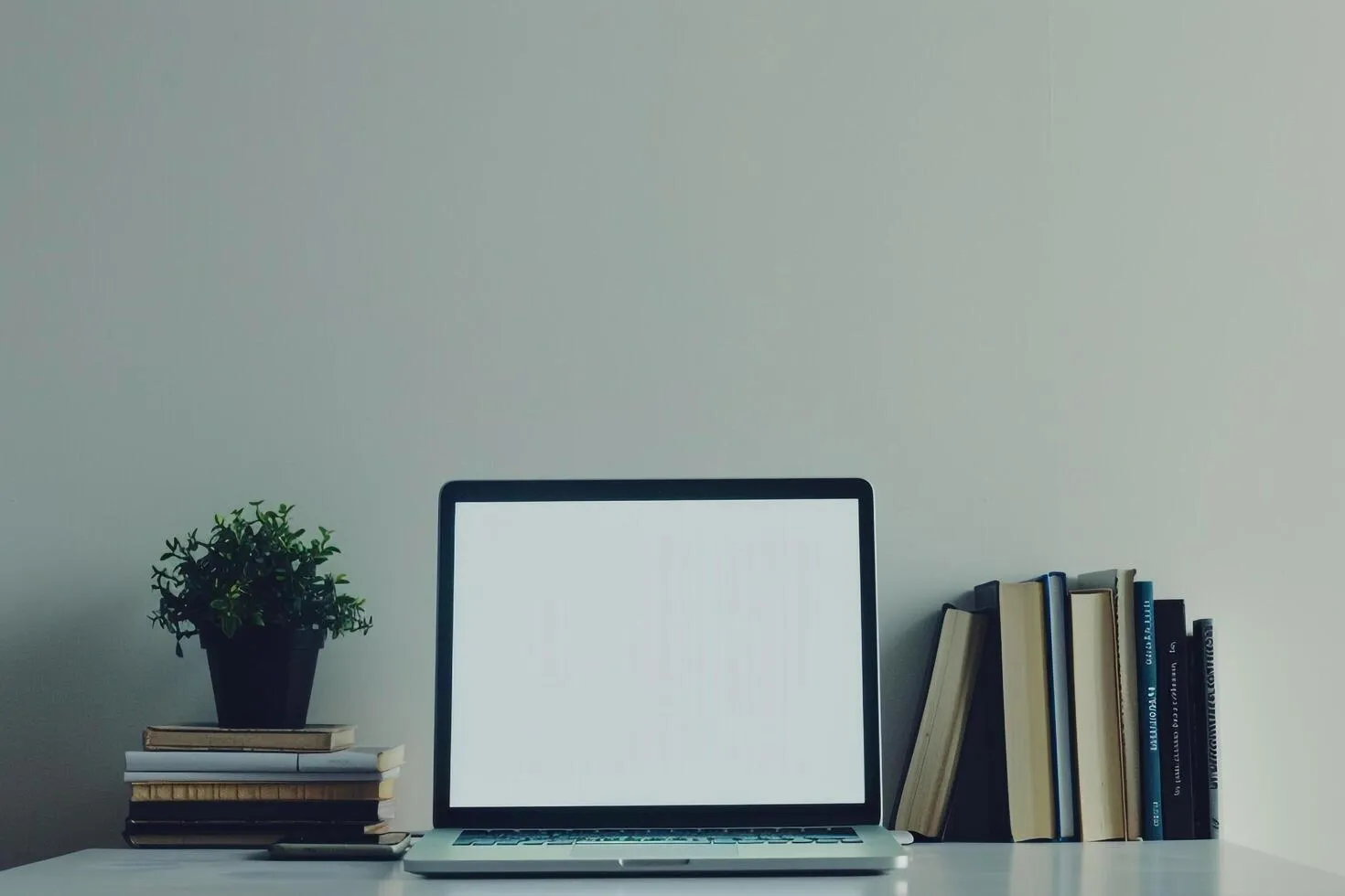 Laptop Mockup with Coding Books in Tech Workspace Background