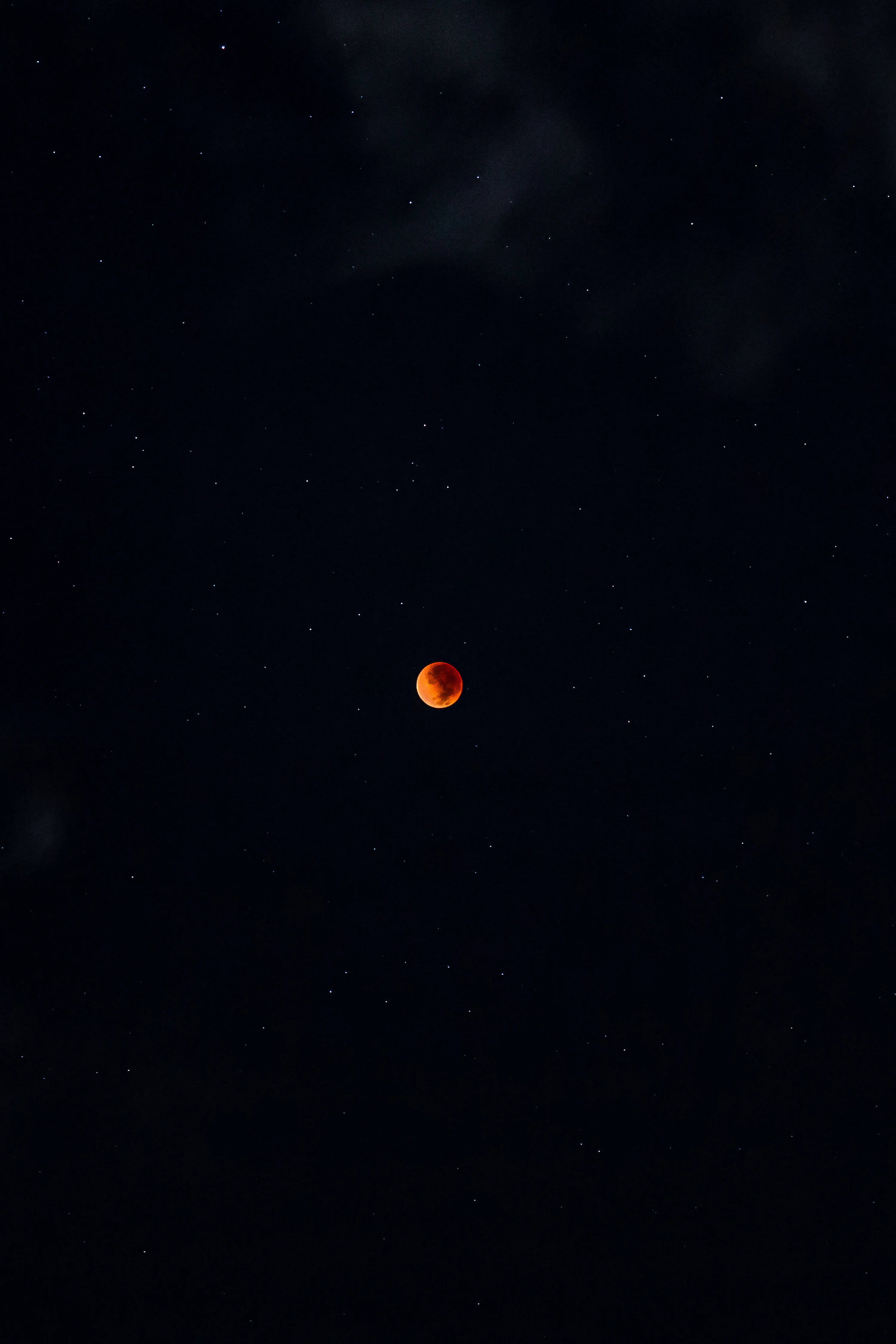 A red moon is seen in the night sky photo