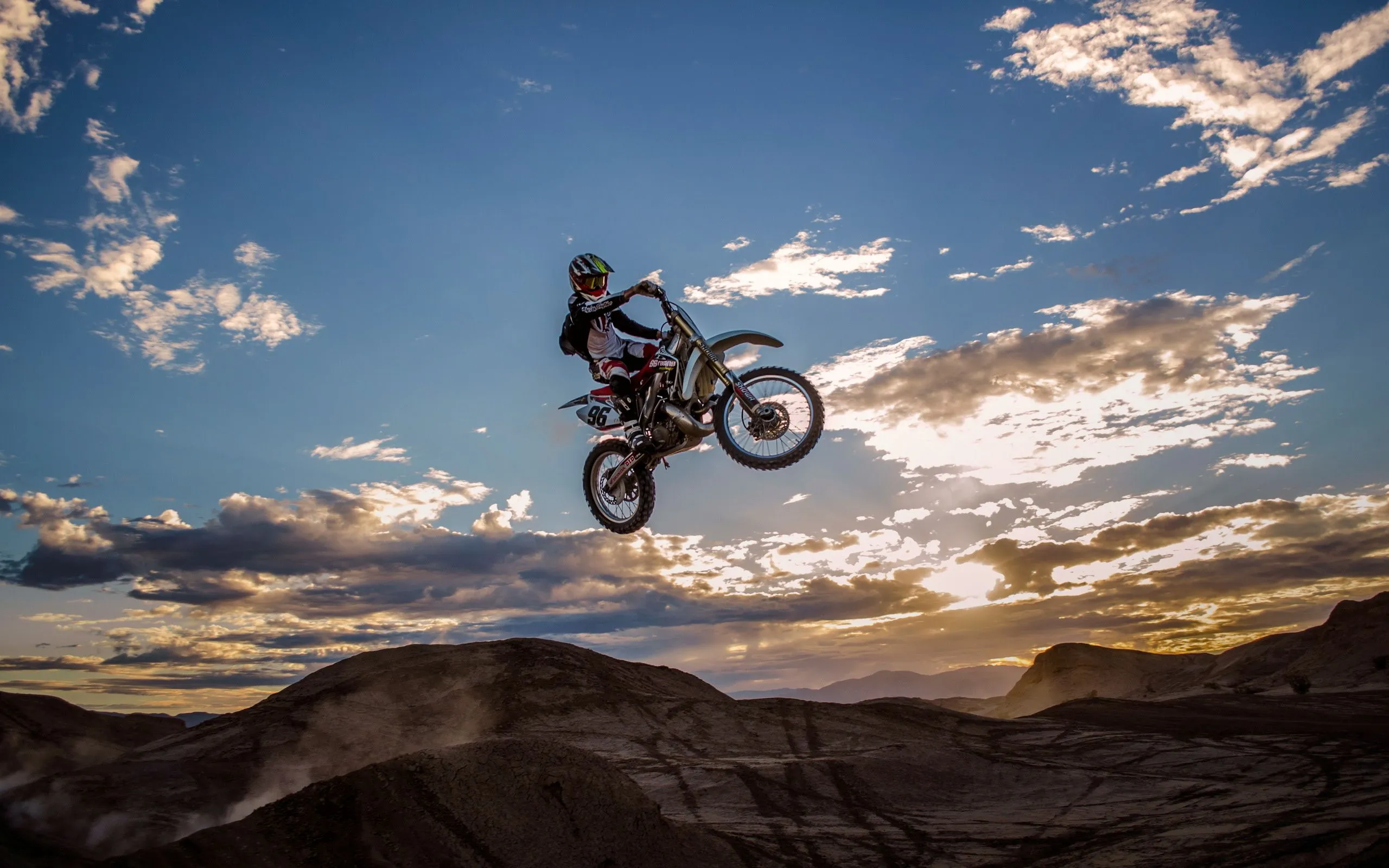 Wallpaper Man Riding Motocross Dirt Bike on Brown Mountain Under Blue Sky During Daytime, Background Free Image