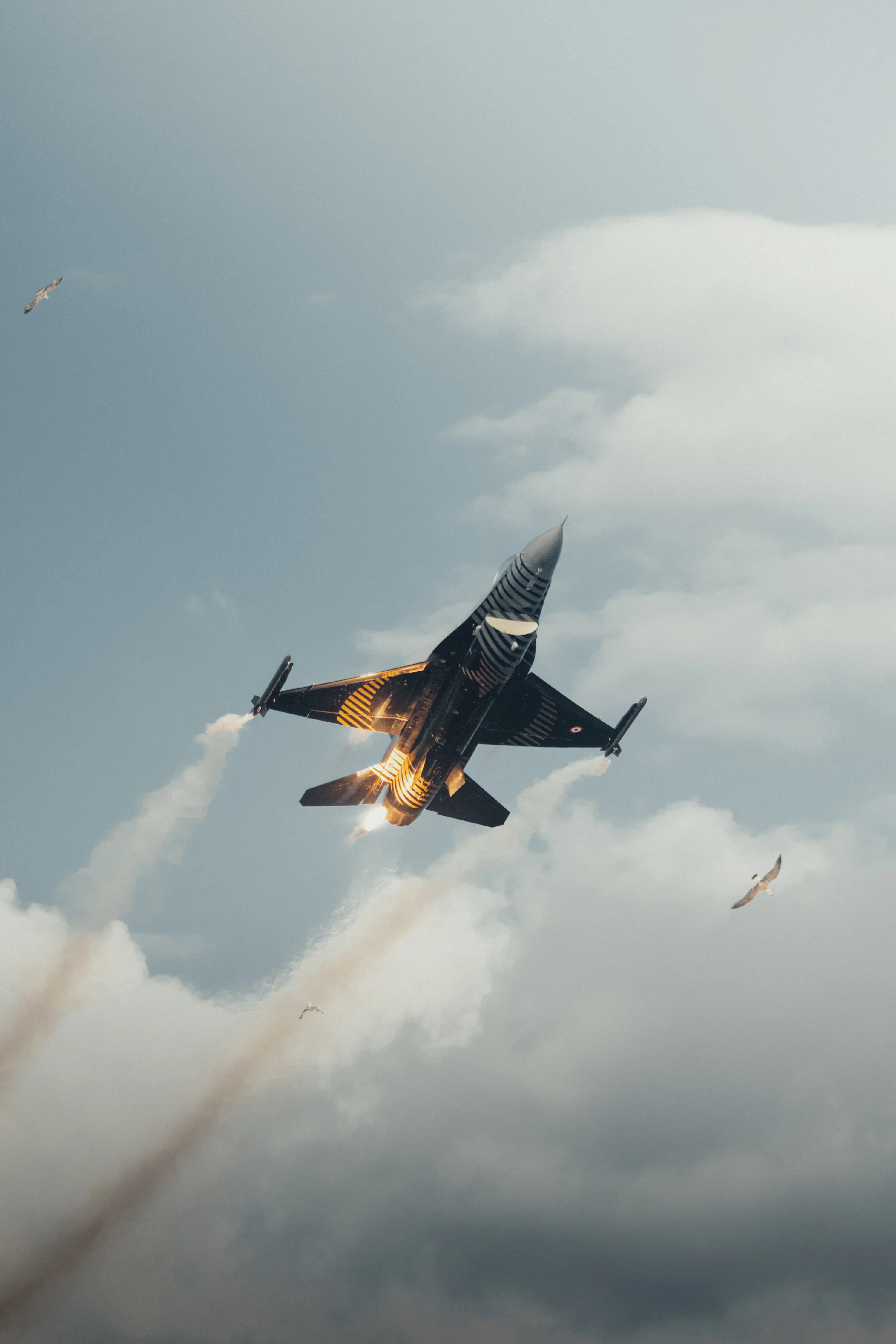 A fighter jet flying through a cloudy blue sky photo