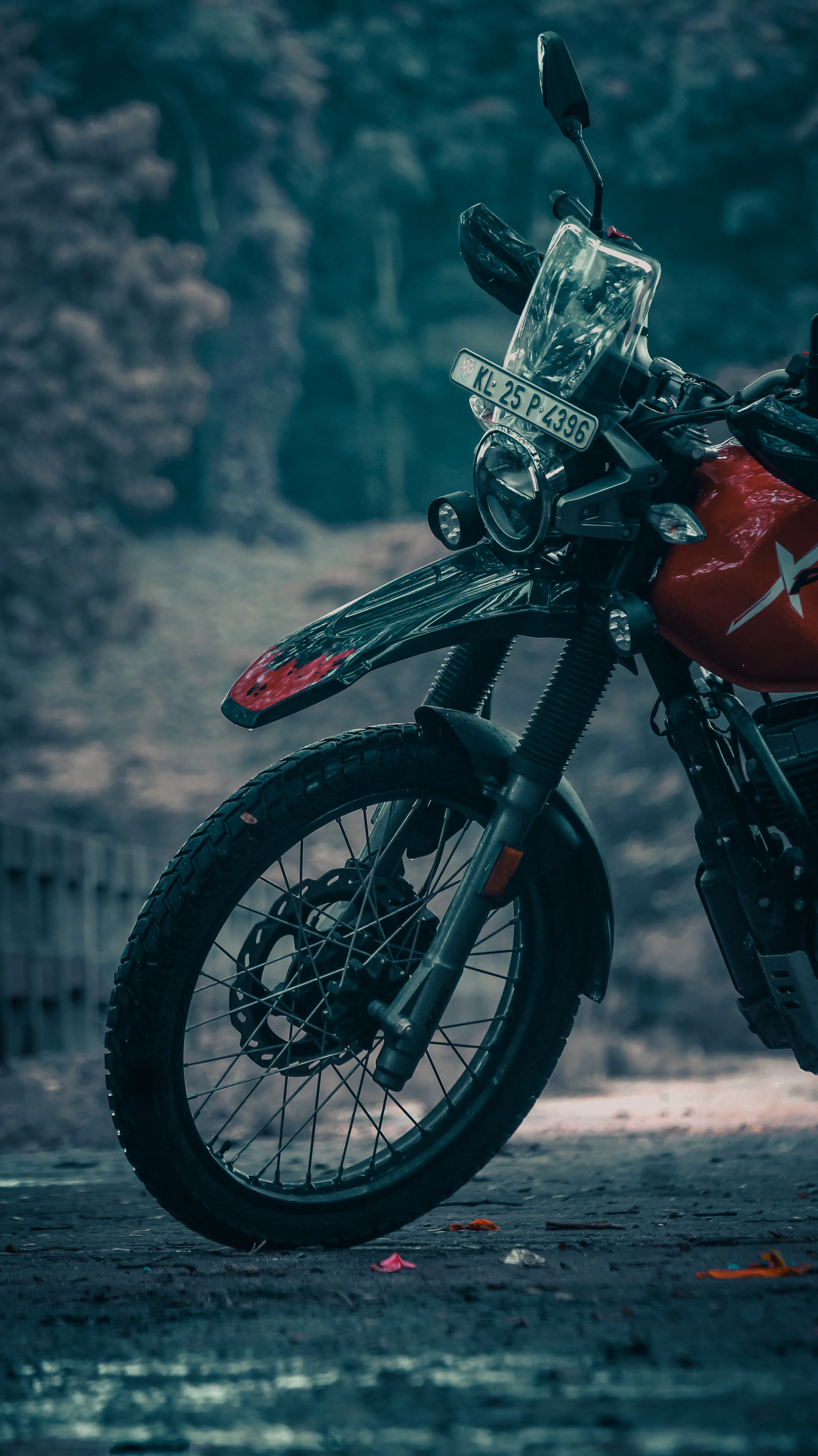 A red and black motorcycle parked on the side of a road