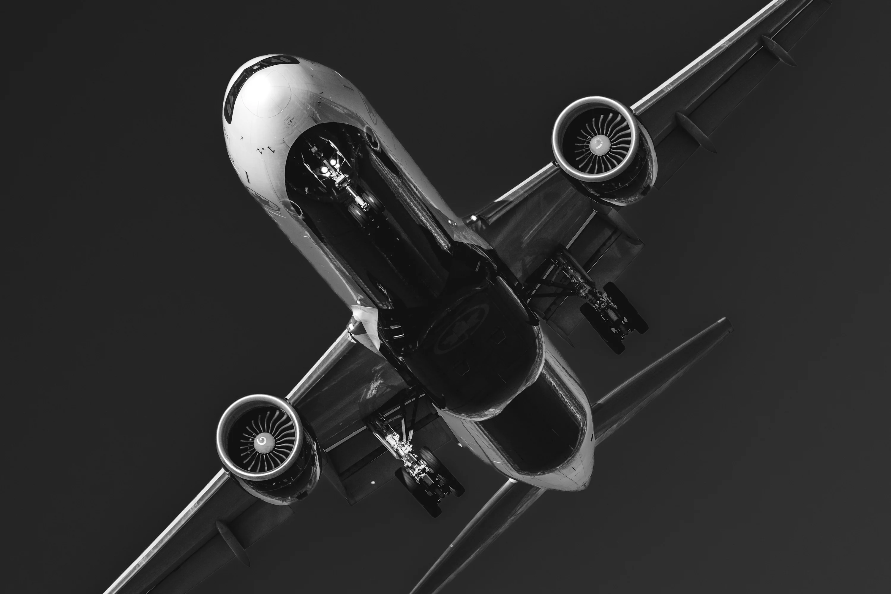 Black and white airplane flying with landing gear extended