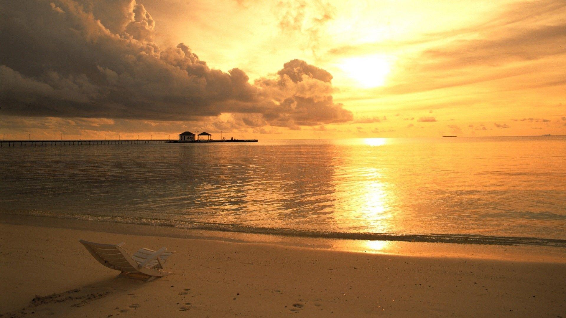 Lonely chaise lounge on the beach at sunset wallpaper and image