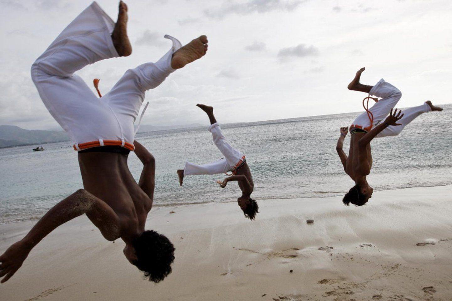A group of men practice capoeira on the beach in Dili wallpaper