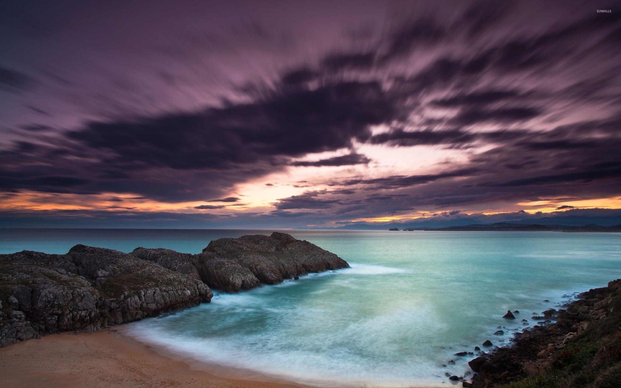 Purple clouds above the rocky ocean shore wallpaper wallpaper