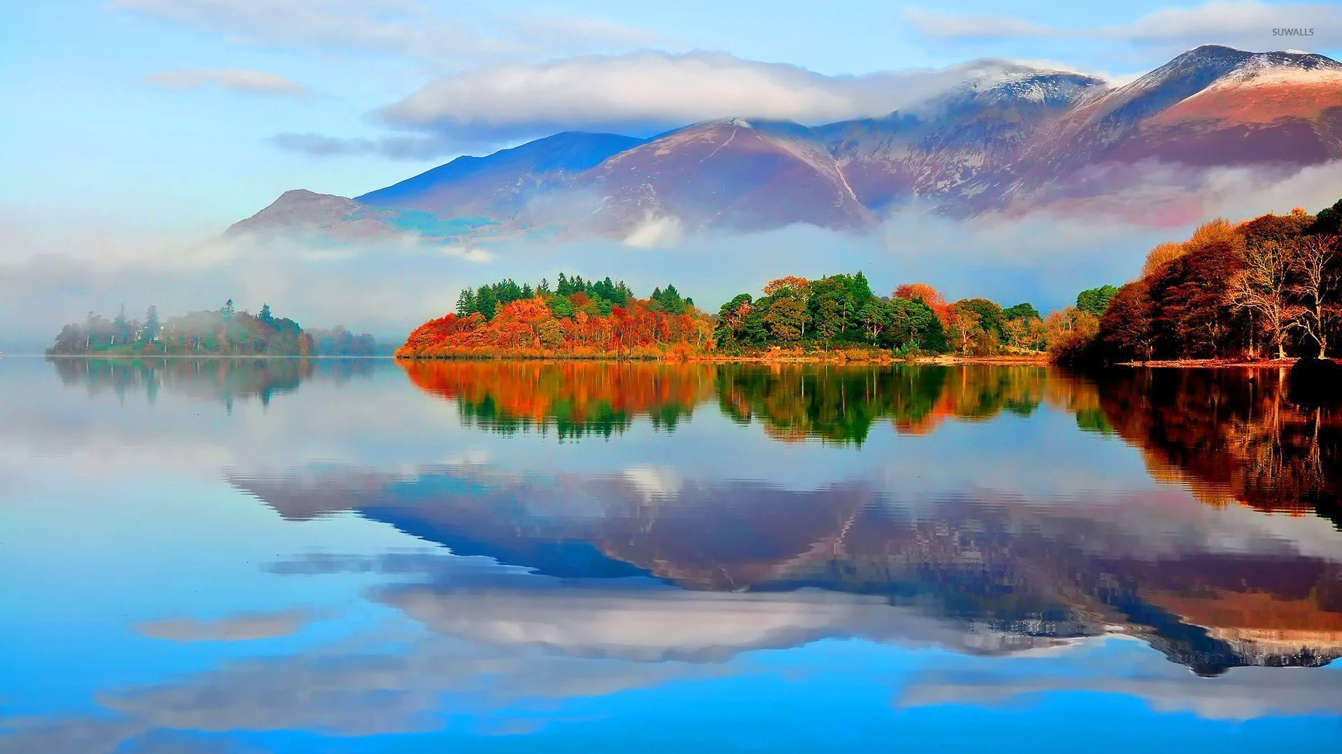Lake reflecting the cloud covered mountains wallpaper