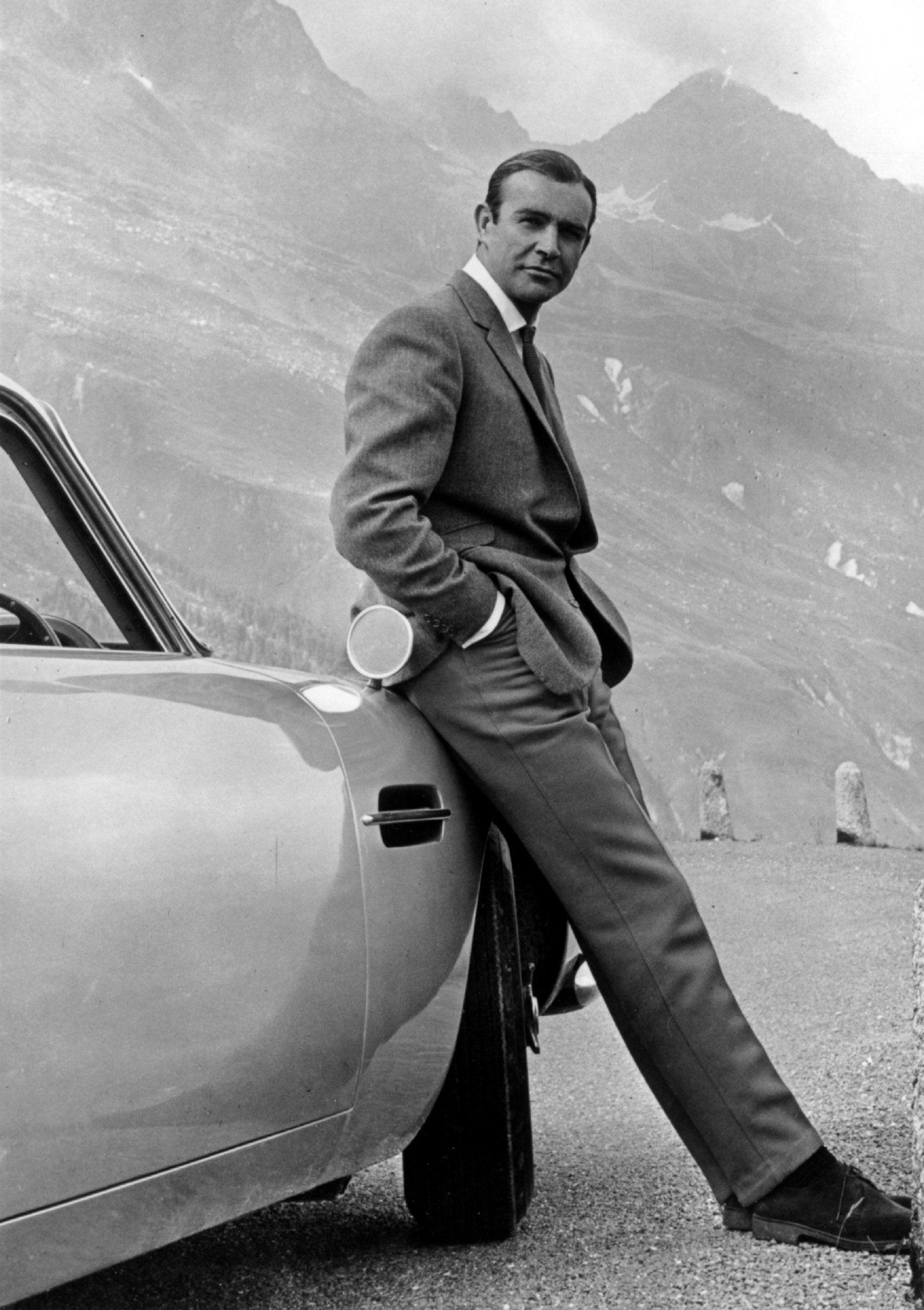 PHOTO: Actor Sean Connery poses as James Bond next to his Aston