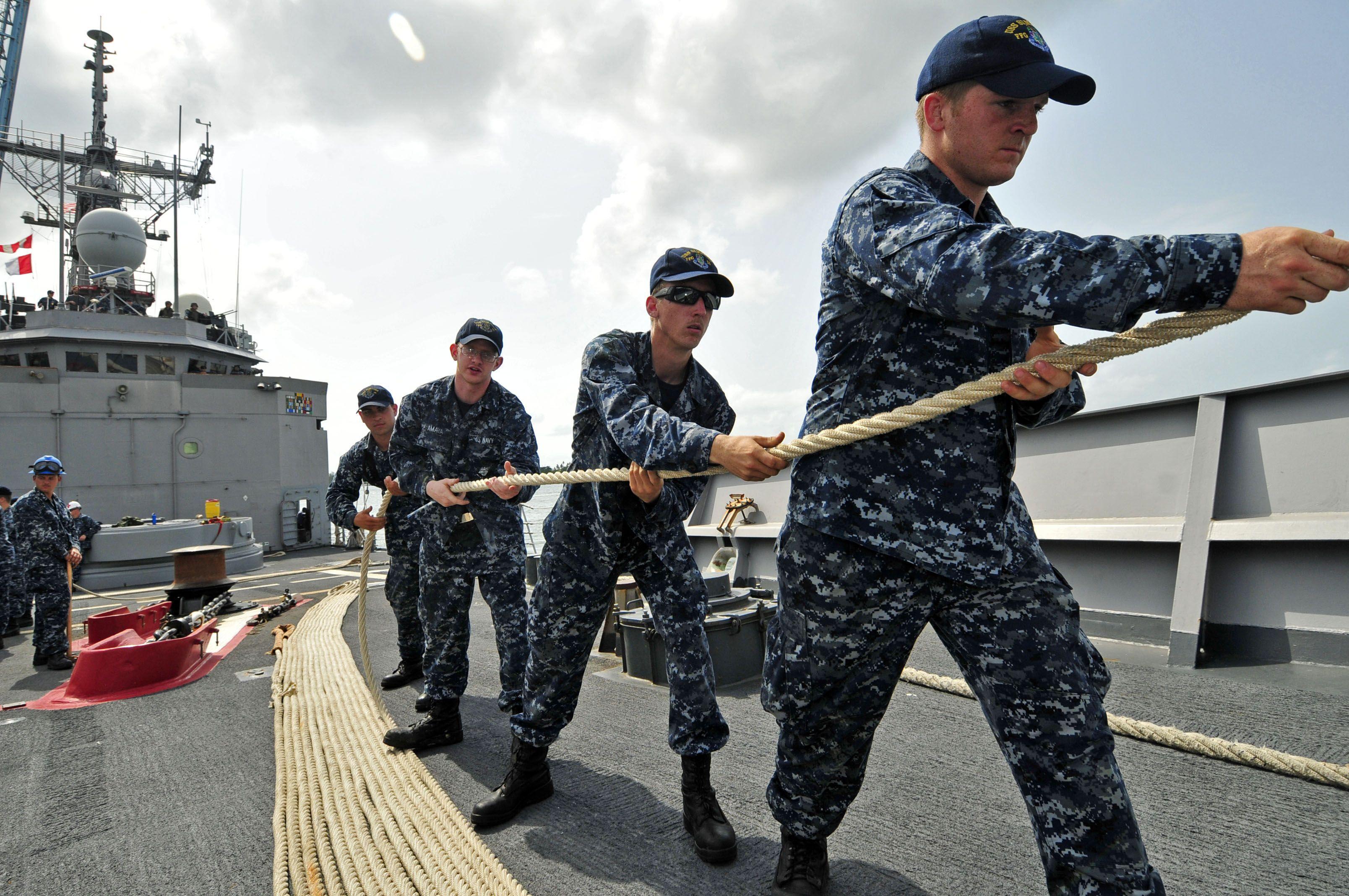 U.S. Sailors heave a line as guided missile frigate USS