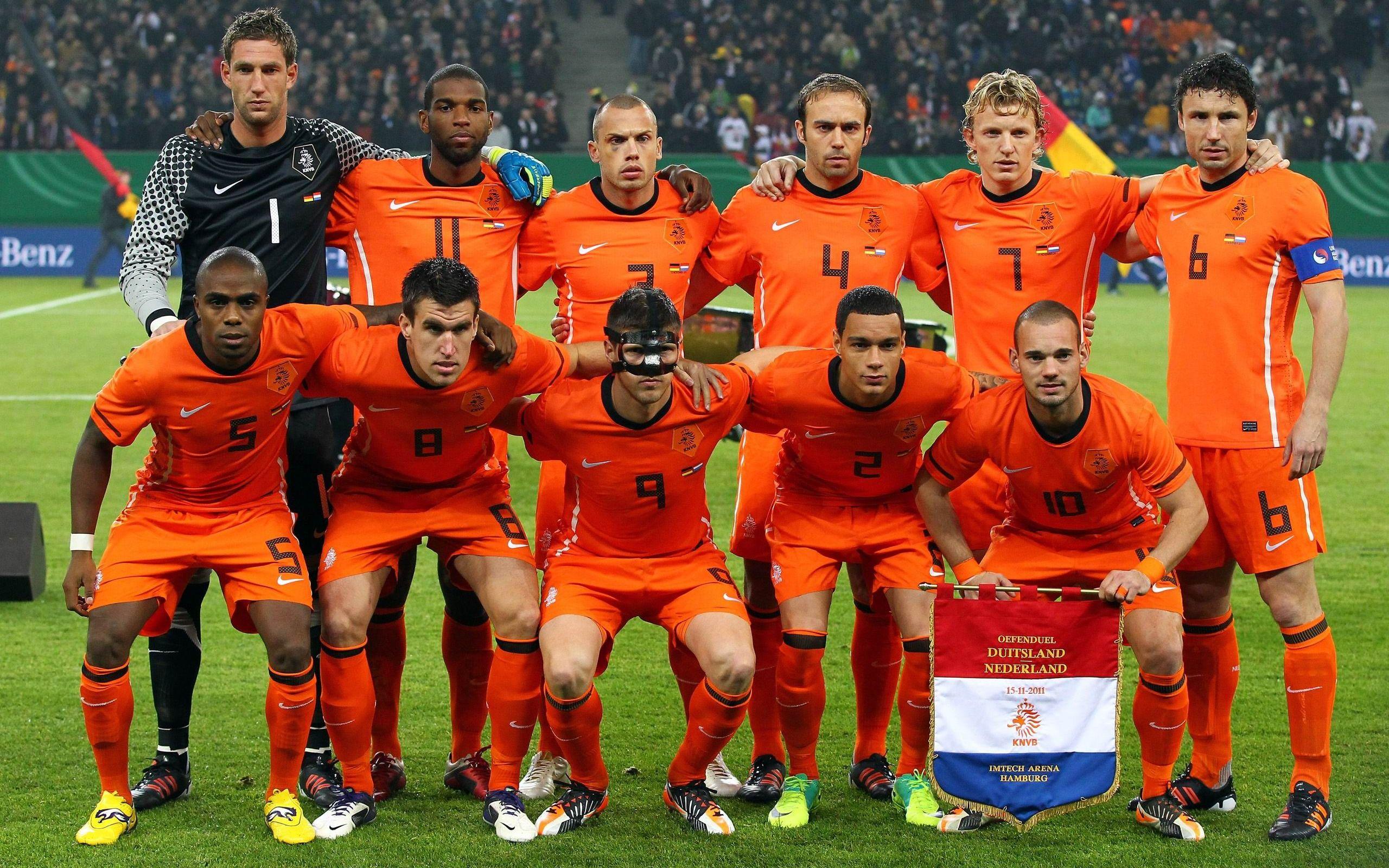  The image shows the starting lineup of the Netherlands national football team, wearing their orange jerseys, posing for a team photo before a match.
