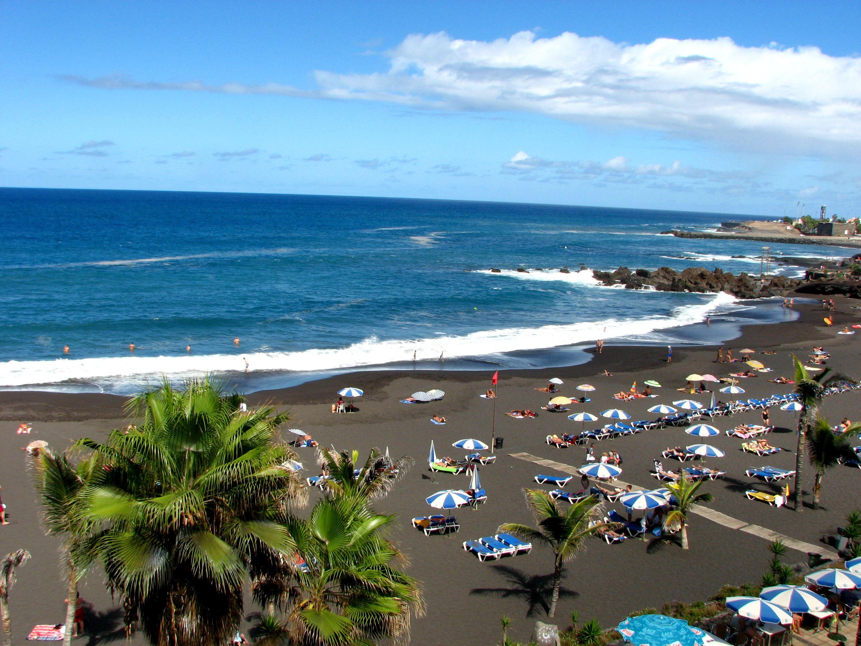 Tourism on the black beach in Tenerife wallpaper and image