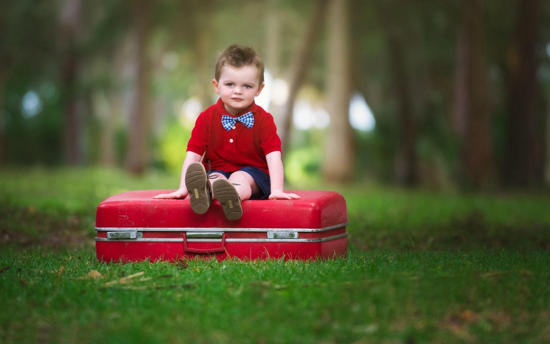 Cute Baby Boy Sitting On Suitcase Wallpaper