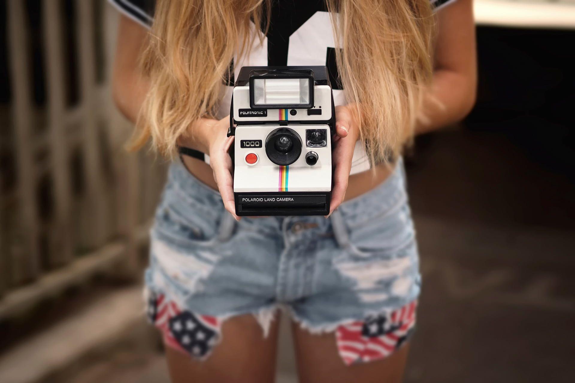 Person holding black and gray Polaroid instant camera HD wallpaper