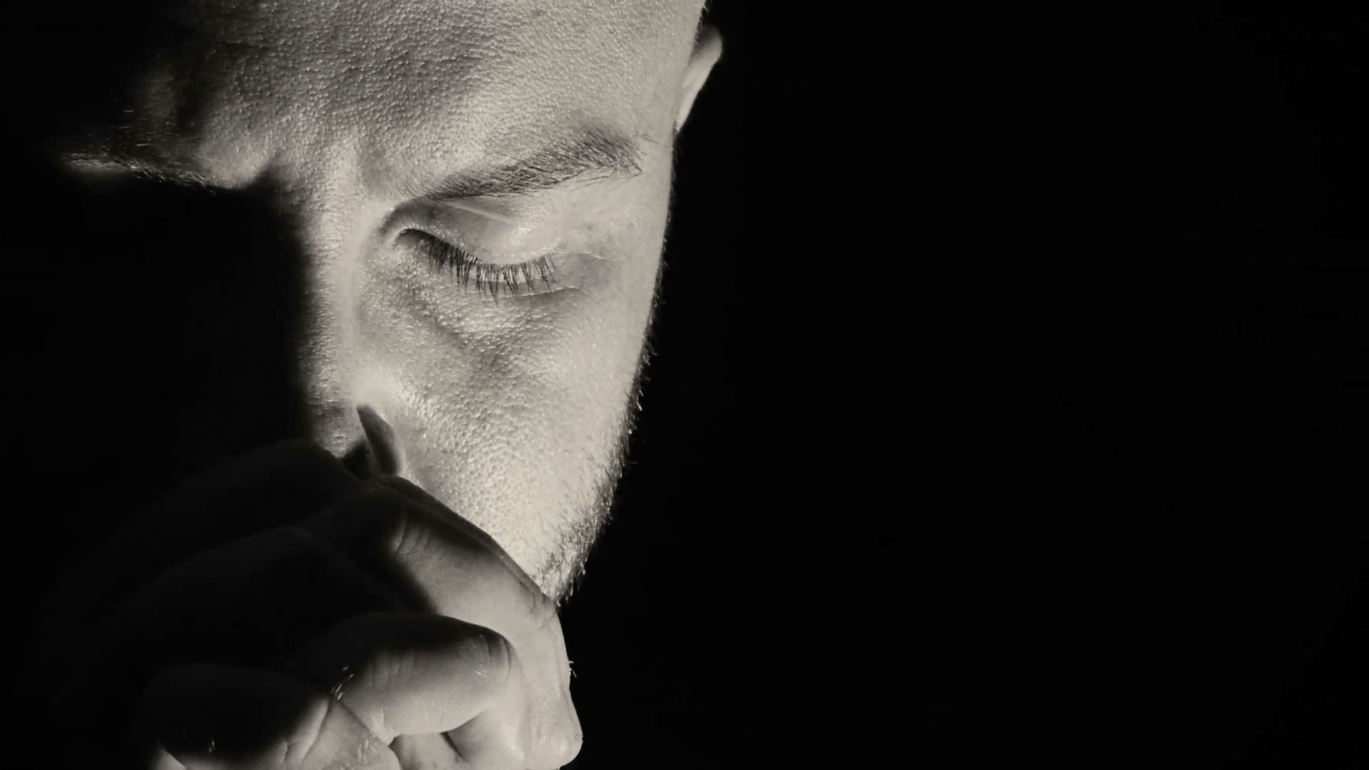 sad man in dark background is thinking about his problems Stock