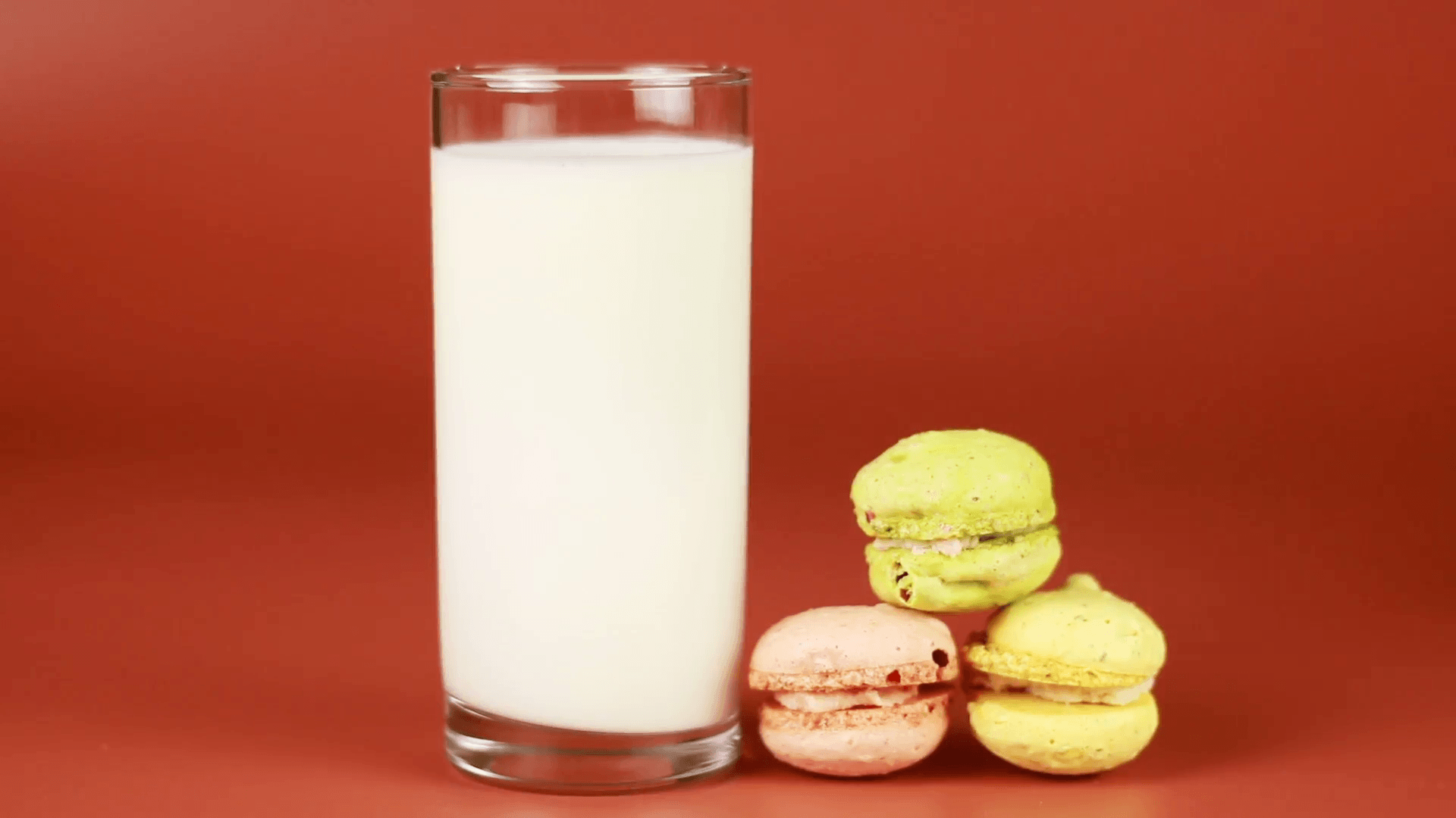 Milk is poured into a glass and strawberry in a wooden bowl on blue