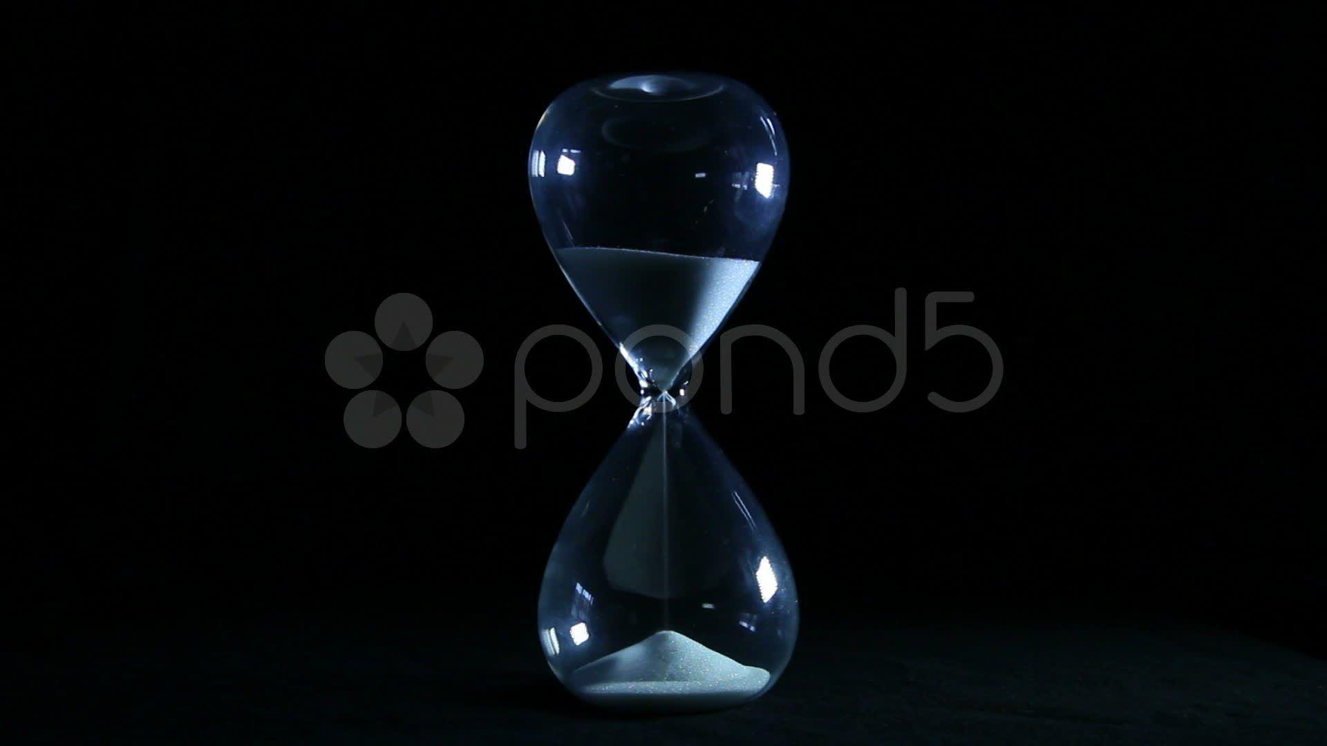 Hourglass on black background Stock Footage