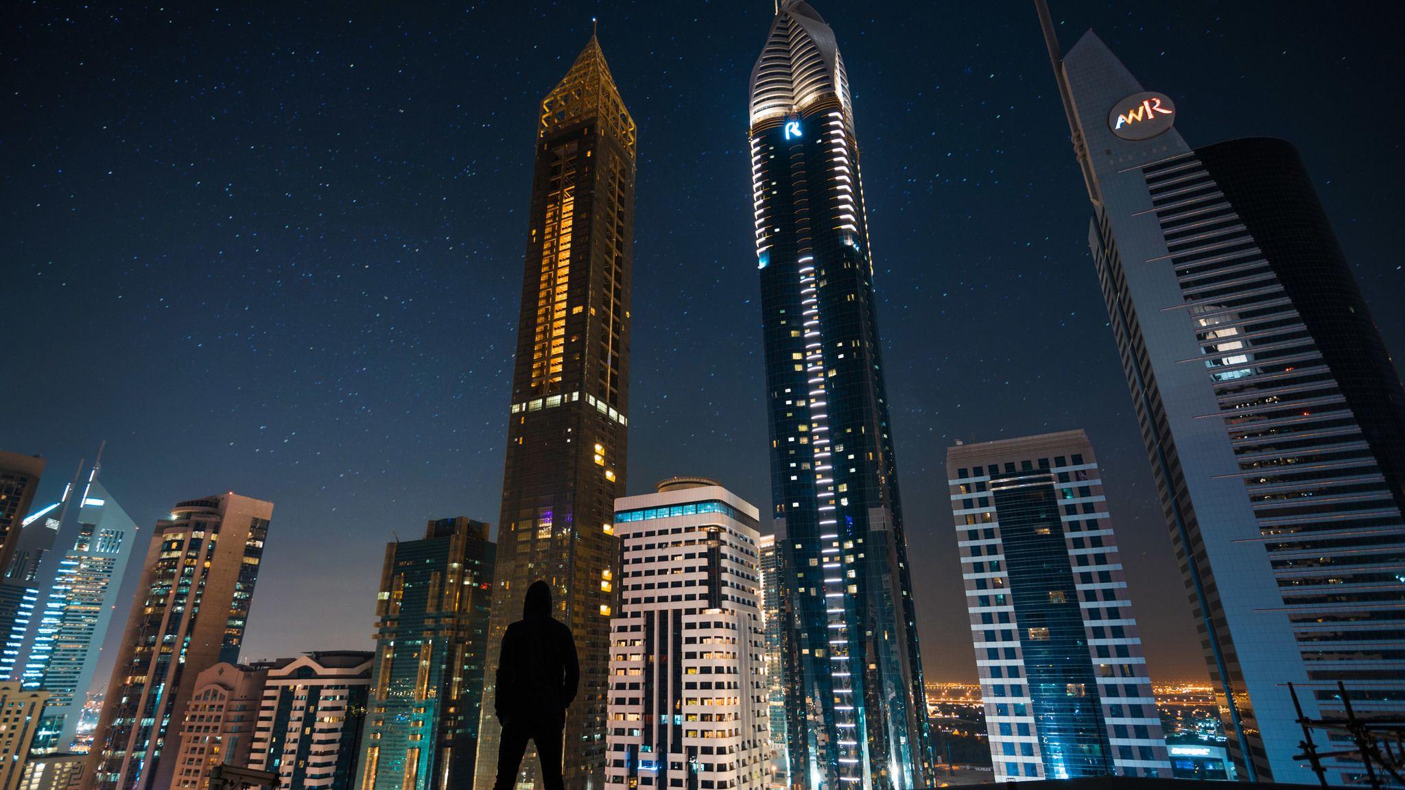Man Standing Front Of Tall Buildings 2048x1152 Resolution