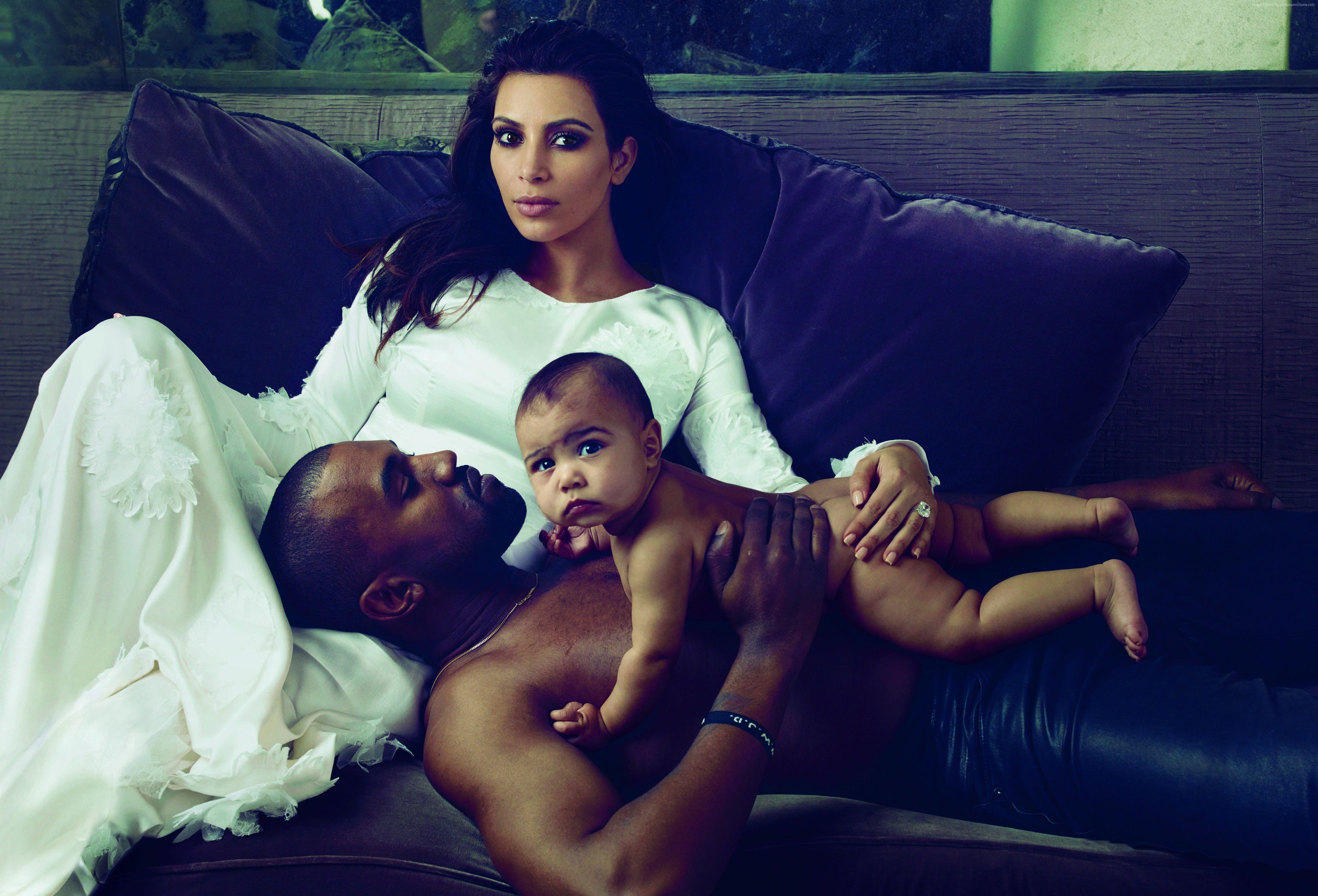 Kanye West, Kim Kardashian, and North West laying on black leather.