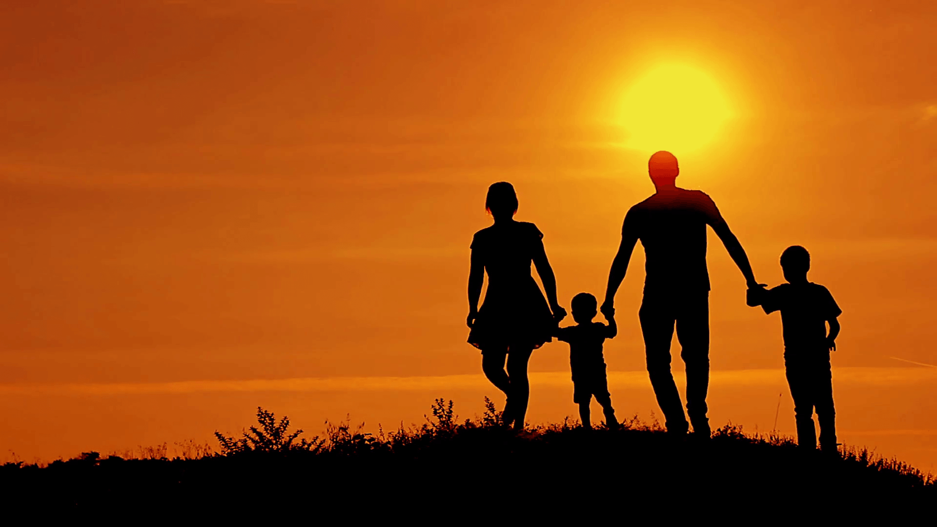 Silhouettes of happy family running on a sunset background Stock