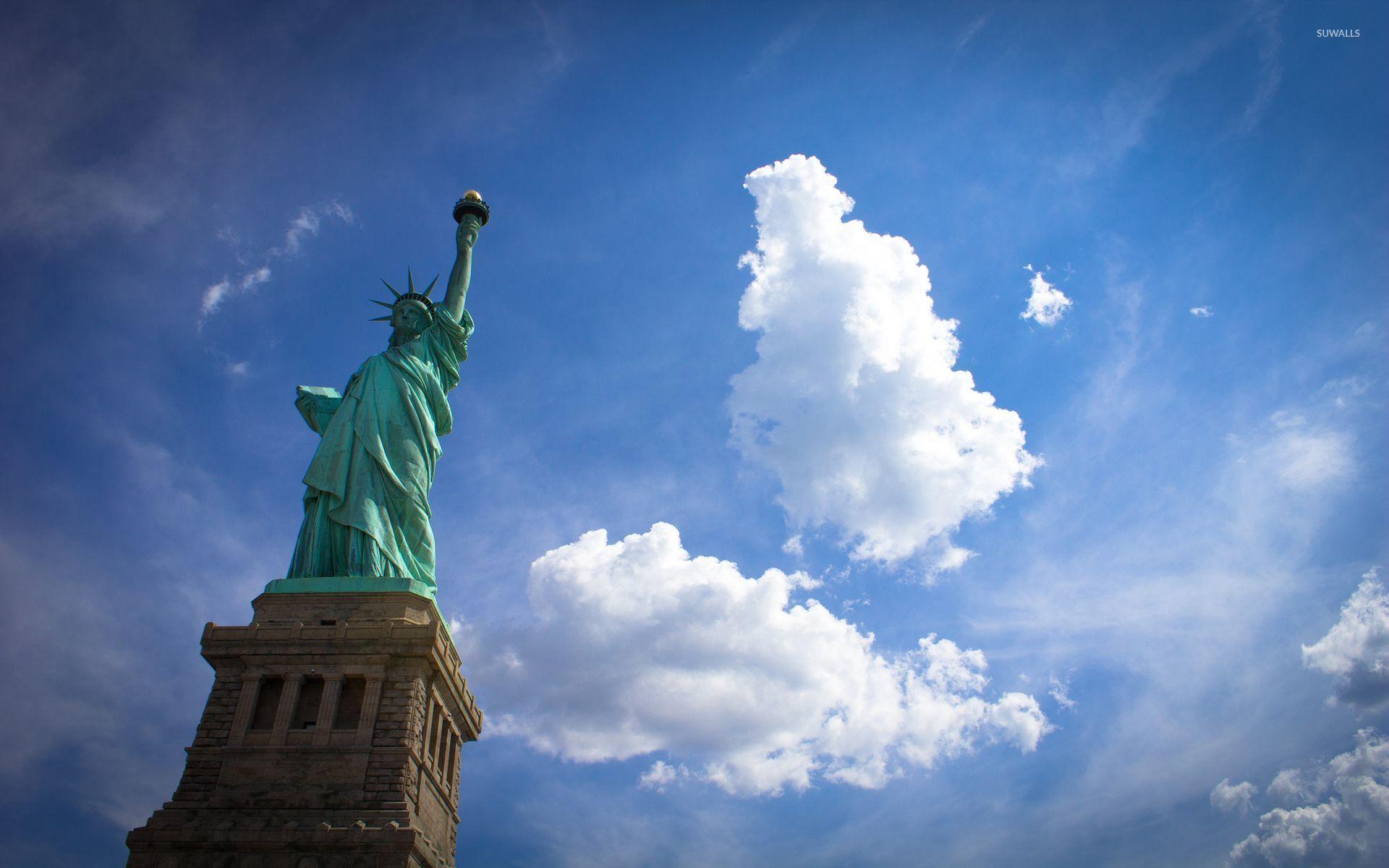 Fluffy clouds above the Statue of Liberty wallpaper