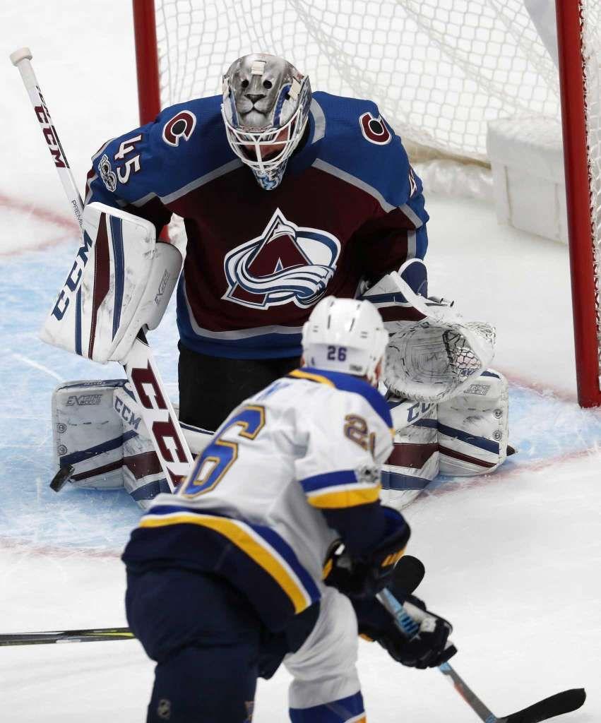 Colorado Avalanche goalie Jonathan Bernier, back, makes a stick save