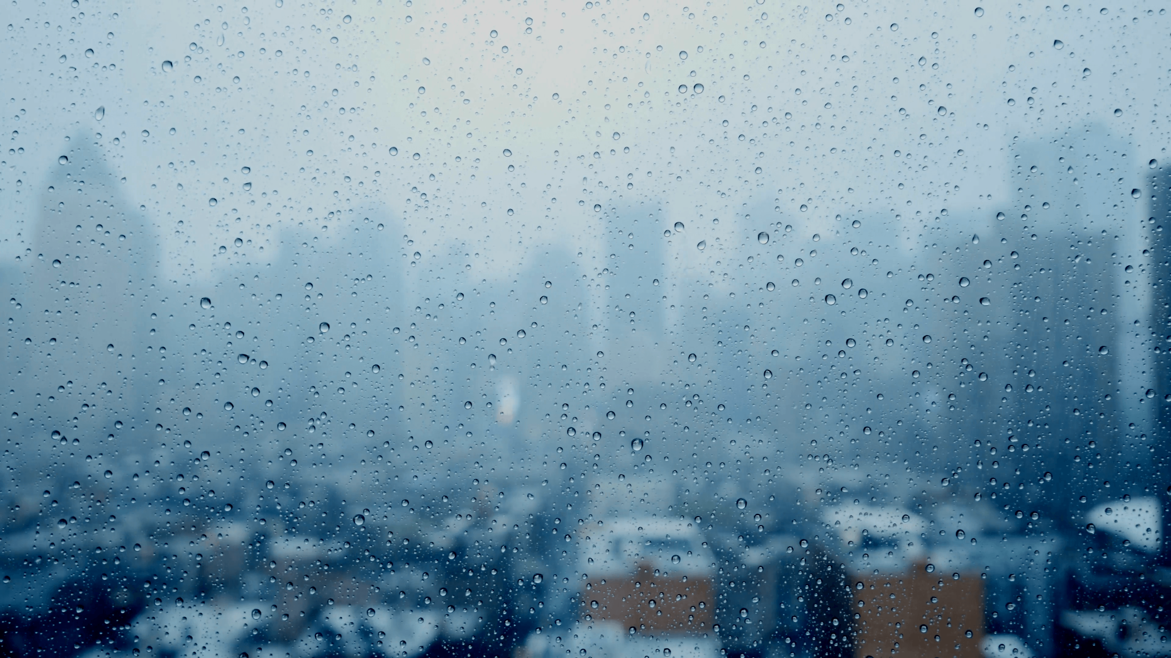 rainy day in the city. rain drops on window glass. depressive mood