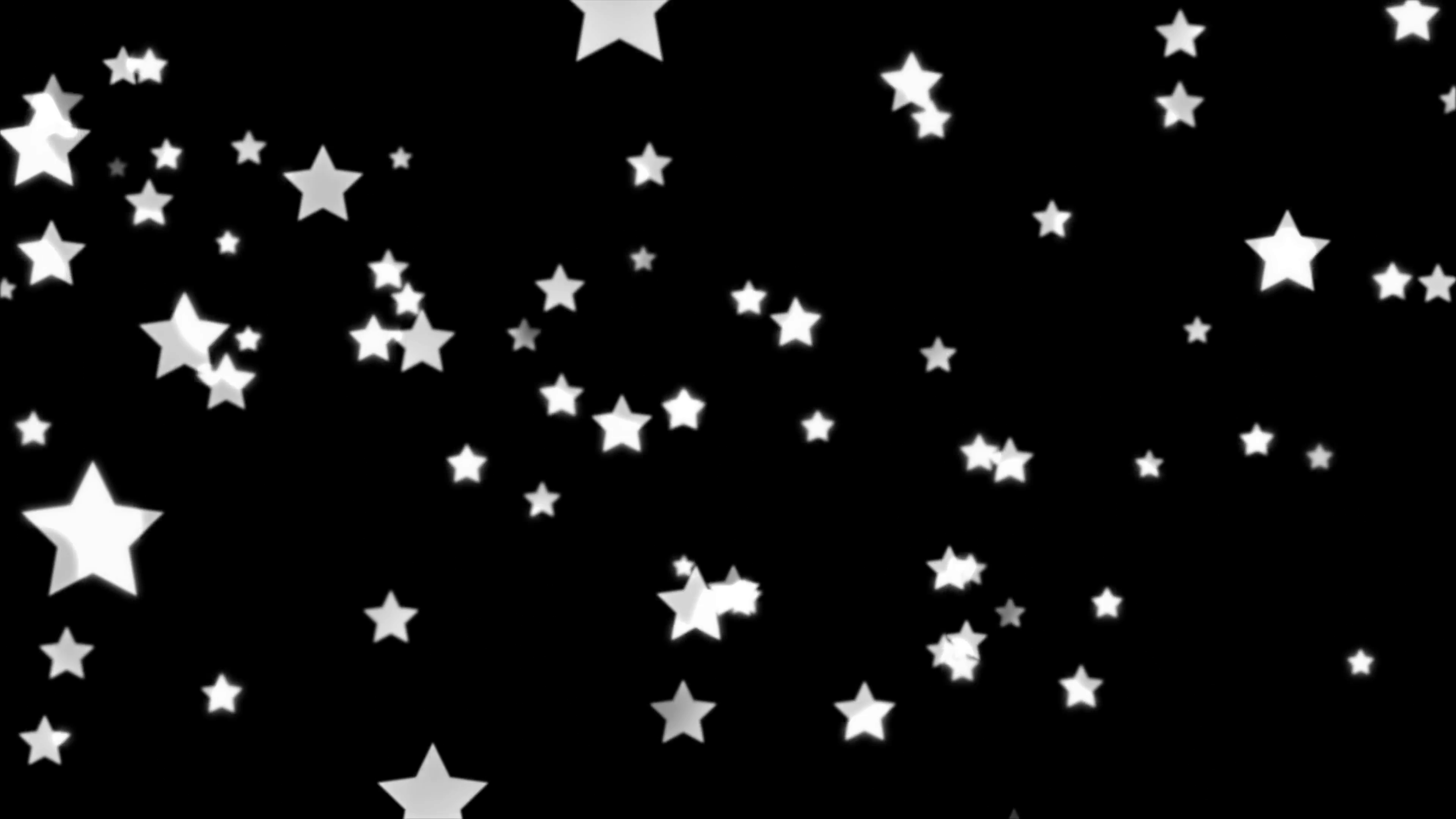 White stars faintly glitter and sparkle as they fall down against a