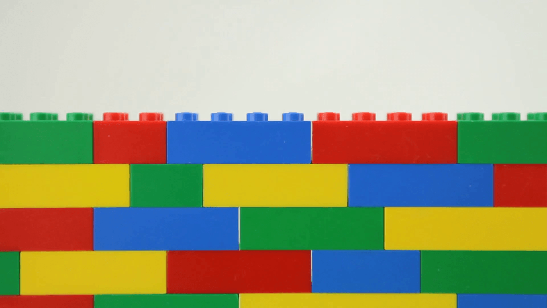 Transition from white background to multi coloured lego wall. Stock